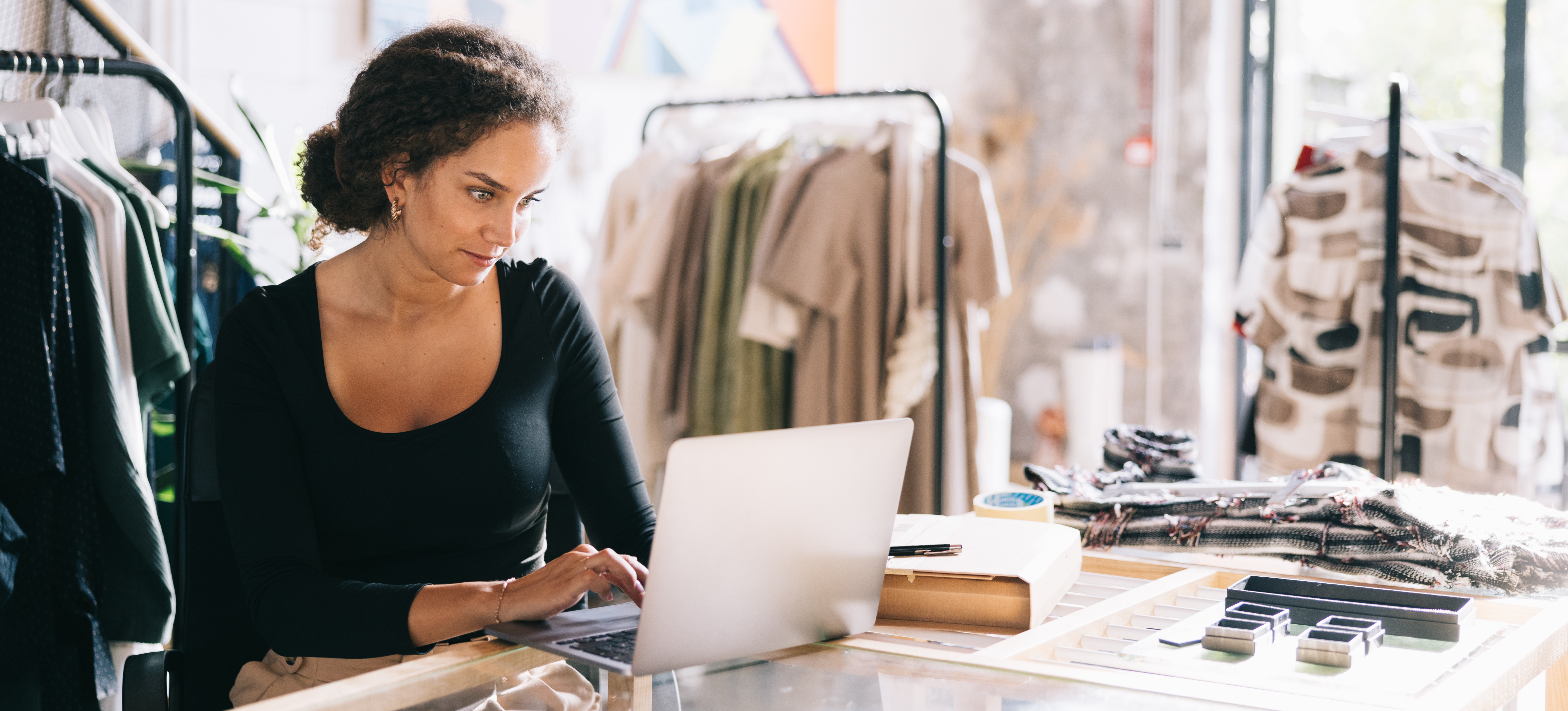 [Featured Image] A dress shop owner learns how to use GIFs in Google Display Ads as they sit a their laptop in their shop.