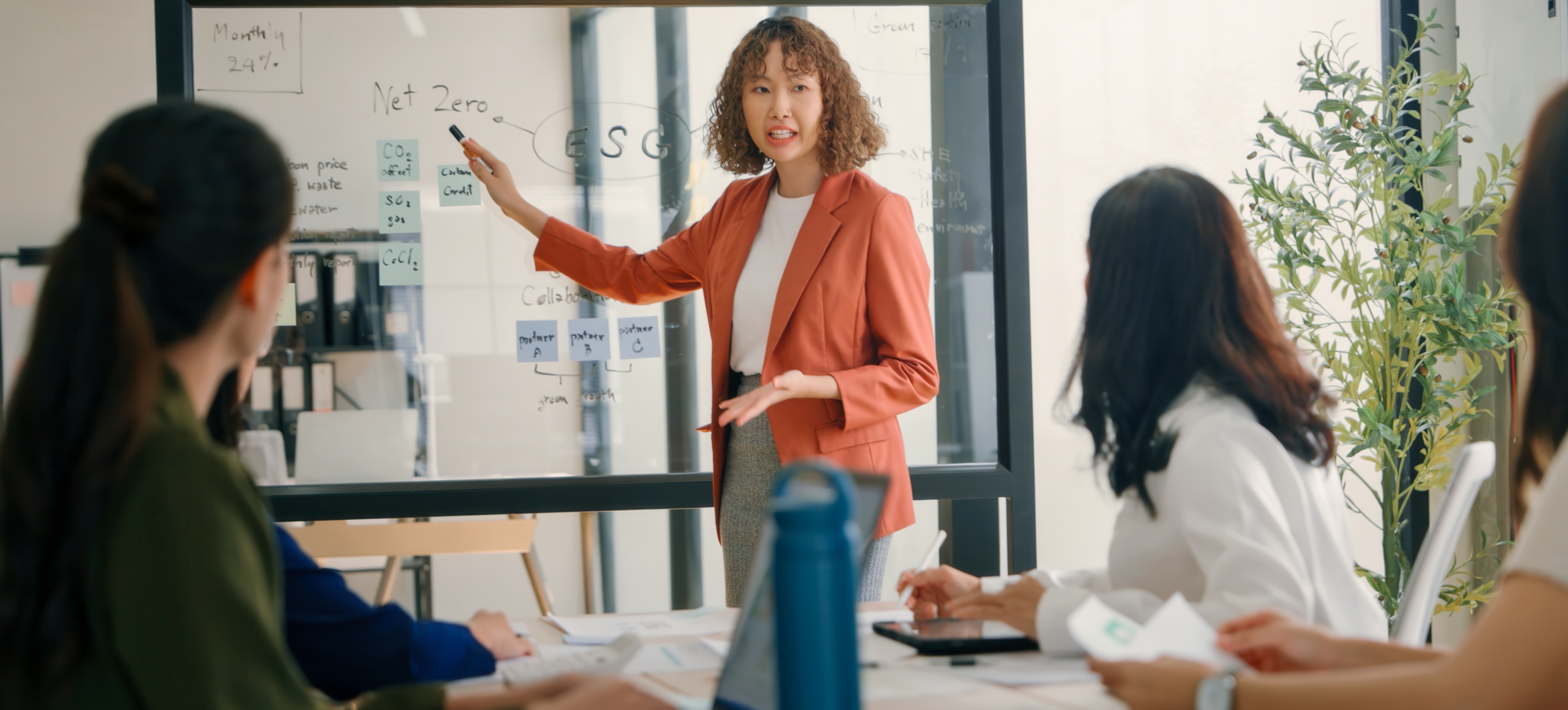 [Featured Image] A professional leading a meeting on strategy with their team in a modern office, discussing key project management skills.
