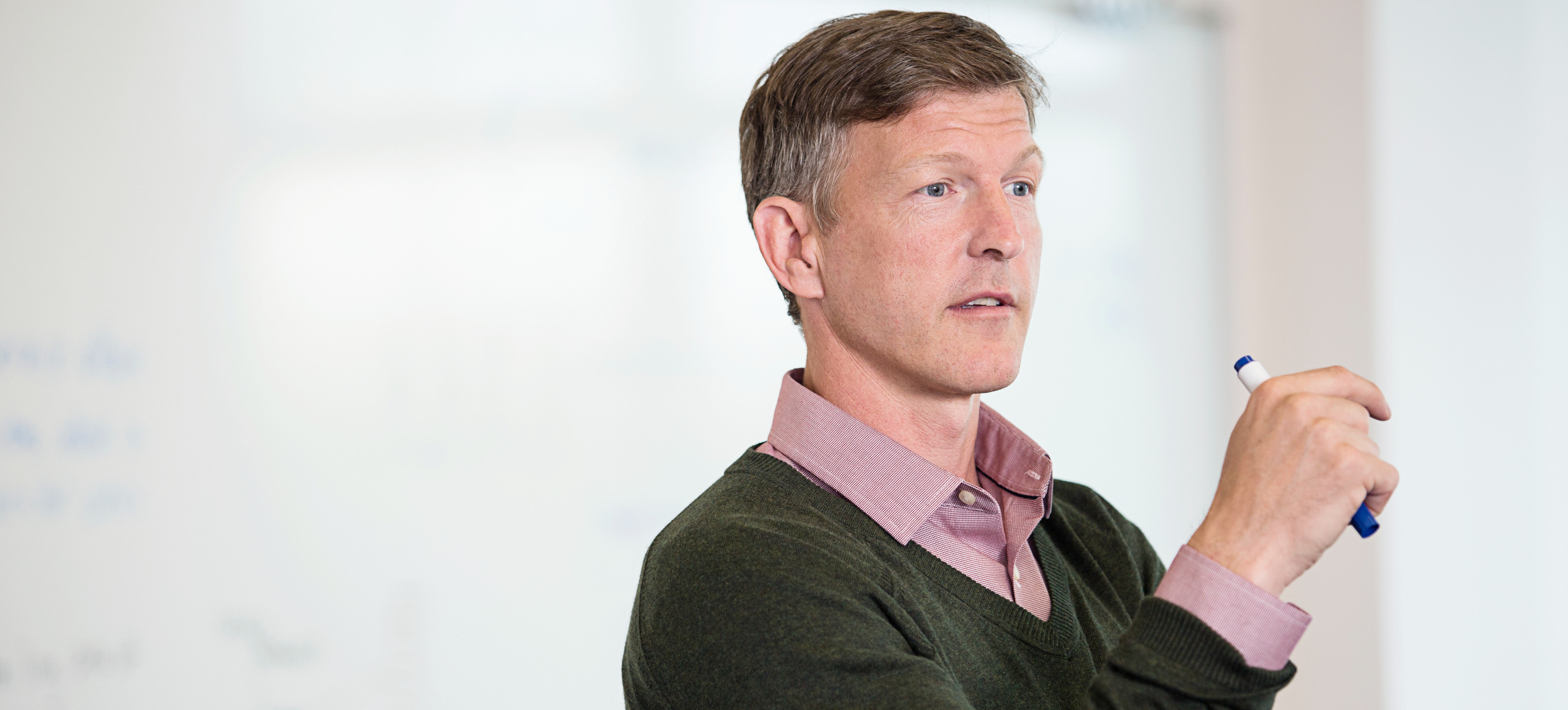[Featured Image] A professor stands in front of a classroom and gives a lecture on how neural networks work. 
