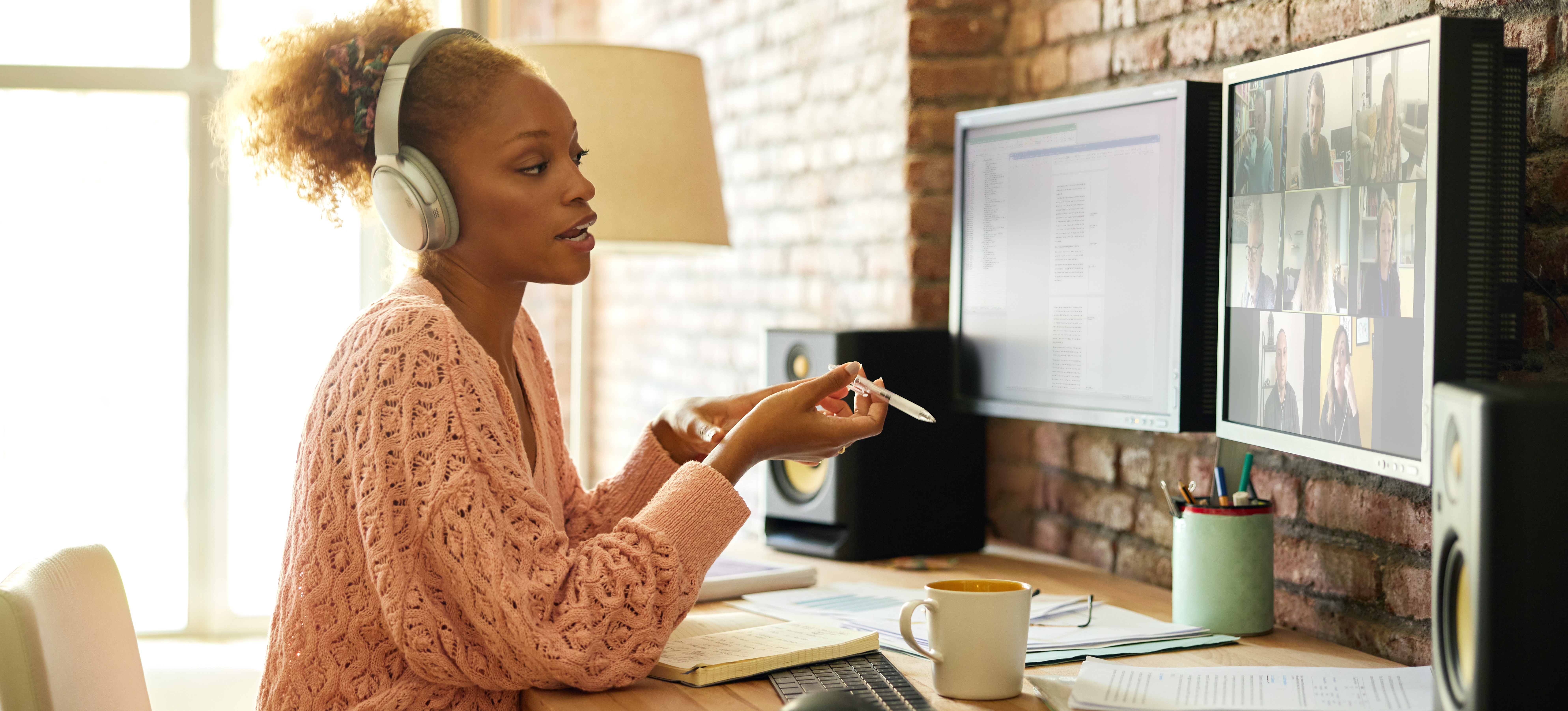 [Featured Image] A UX designer meets virtually with a team to discuss human-centered design solutions.
