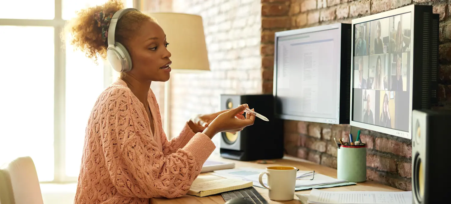 [Featured Image] A UX designer meets virtually with a team to discuss human-centered design solutions.

