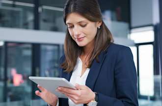 [Featured Image] A business woman uses MDM software on her tablet. 