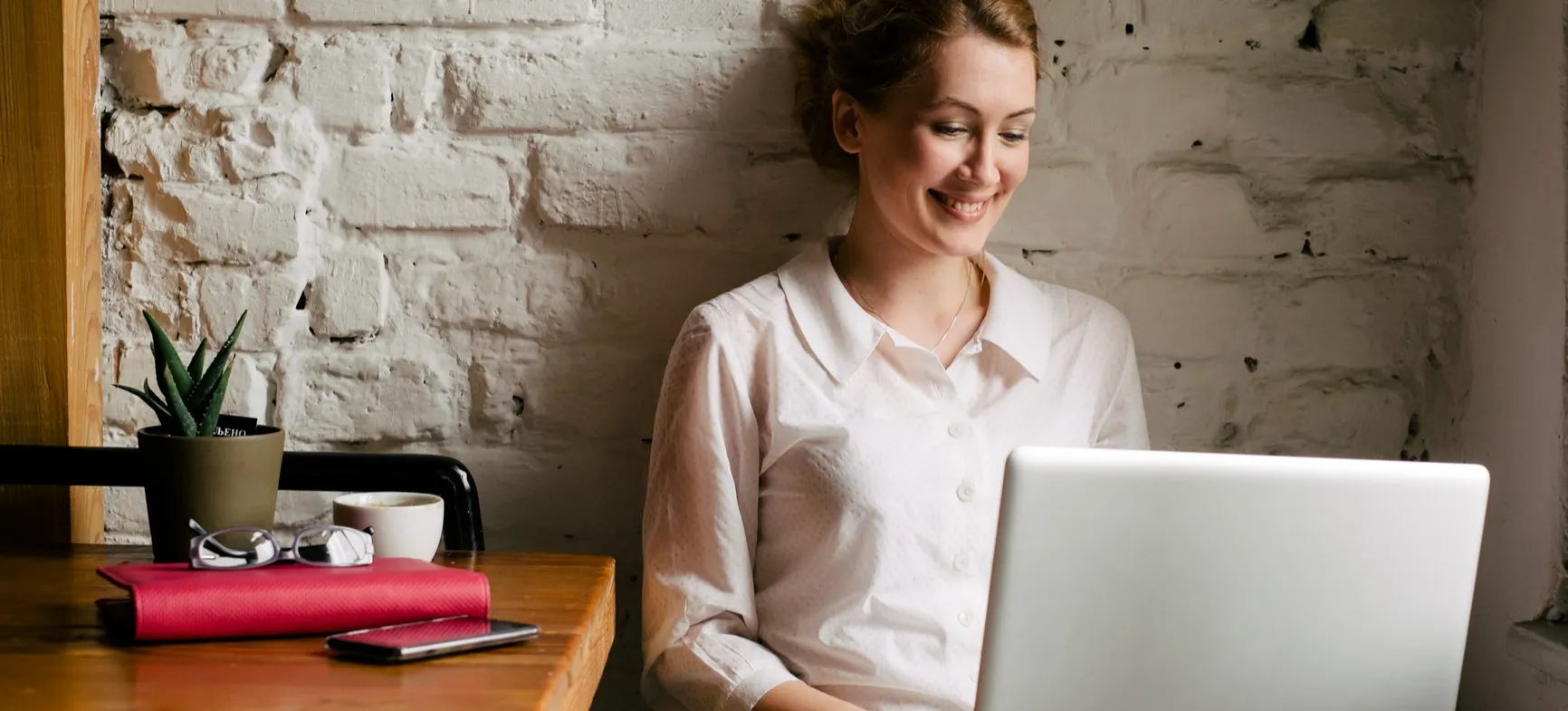 [Featured Image] Candidate writing a cover letter for a project manager position in a cafe