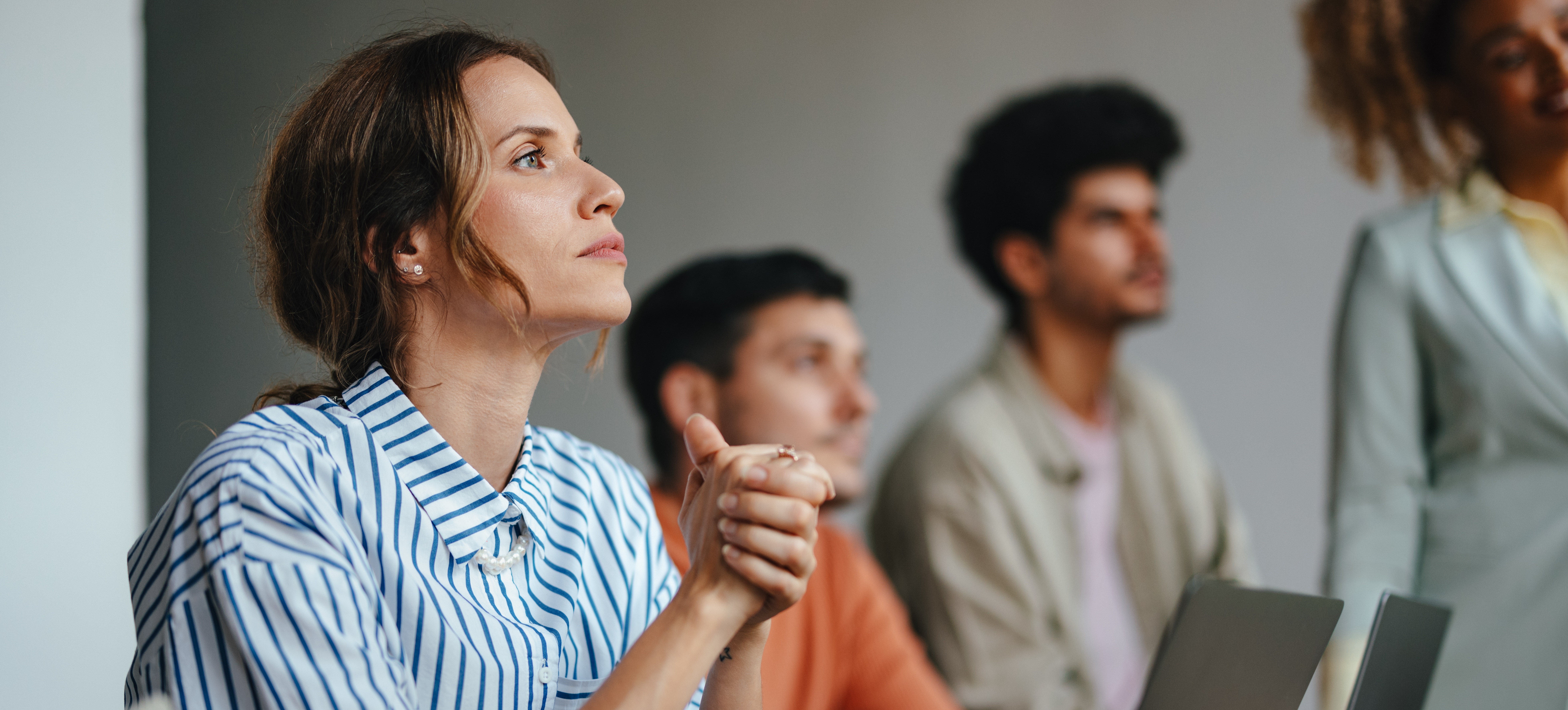 [Image en vedette] Les professionnels participent à la formation en milieu de travail en s'asseyant devant leur ordinateur portable et en écoutant un présentateur.