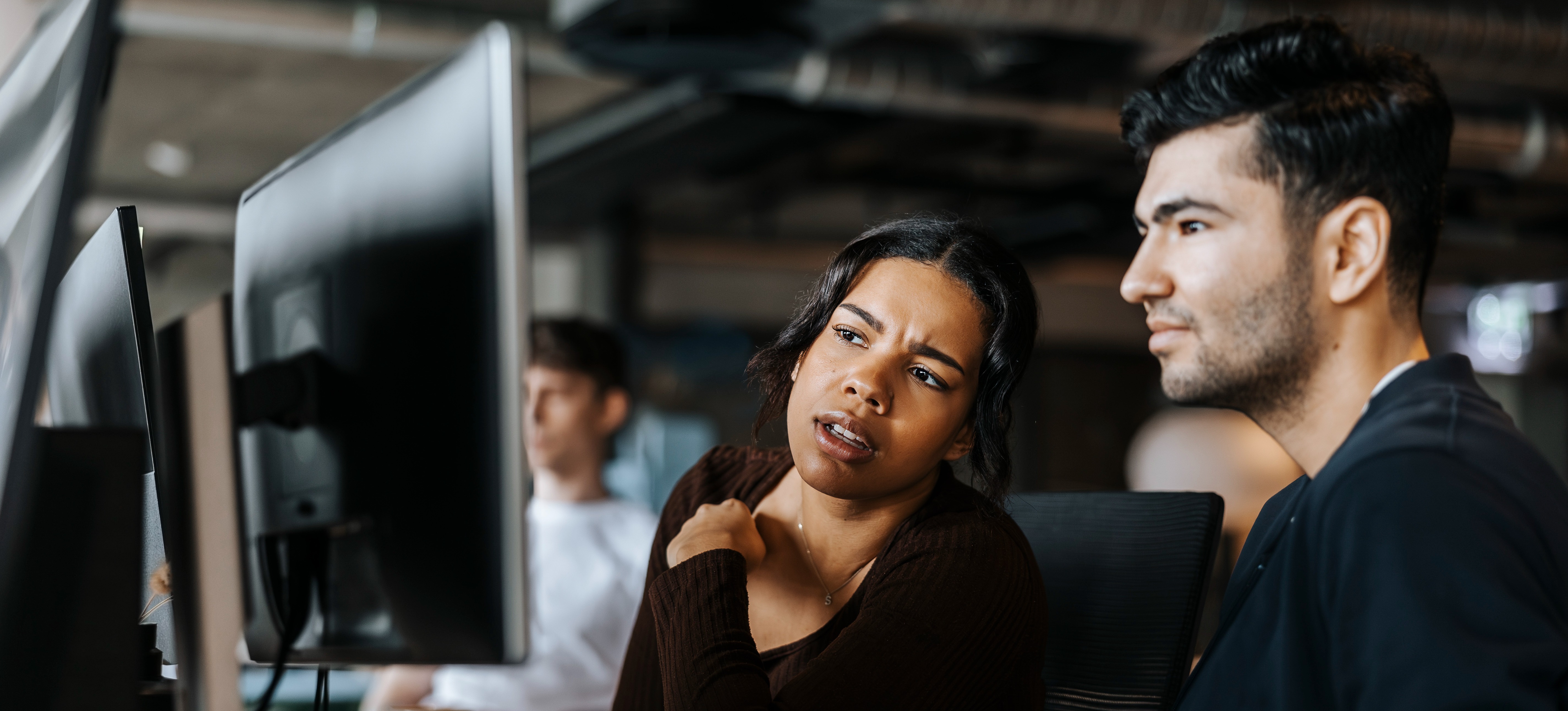 [Featured image] Two coworkers looking at a computer screen are performing analytics consulting for a client. 
