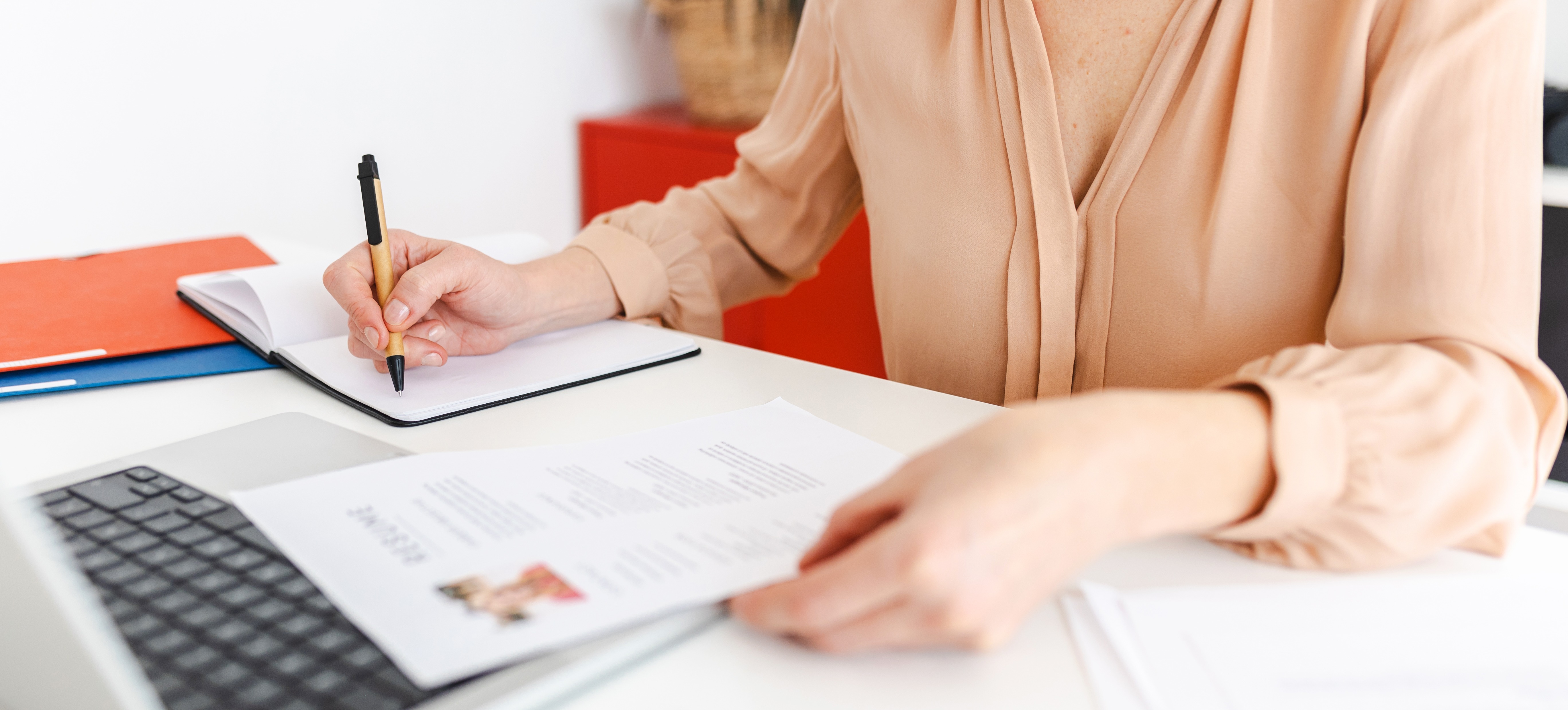 [Featured Image] A professional prepares their resume and job search strategy during a period of frictional unemployment. 
