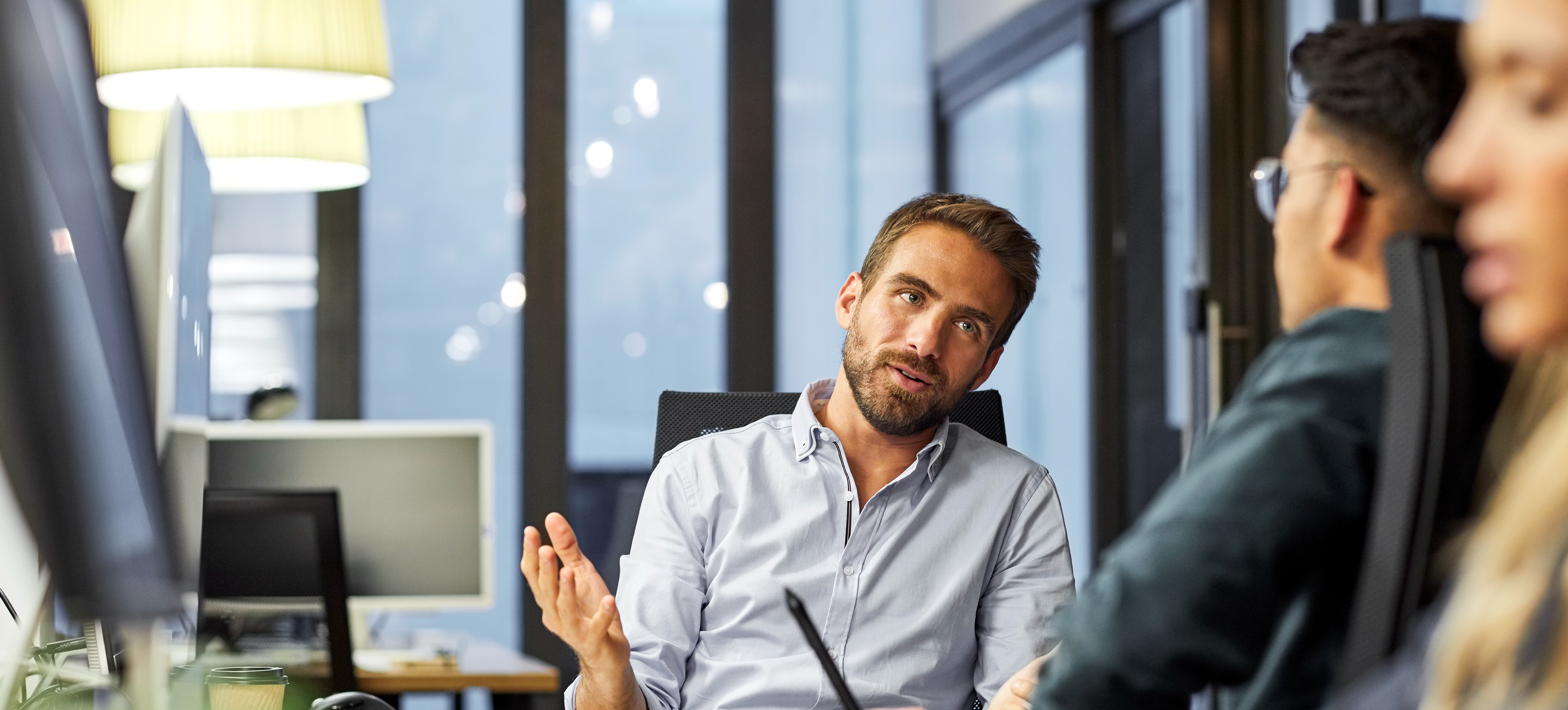 [Featured Image] A solutions architect is meeting with a coworker to discuss the technology solutions to meet the company's needs.