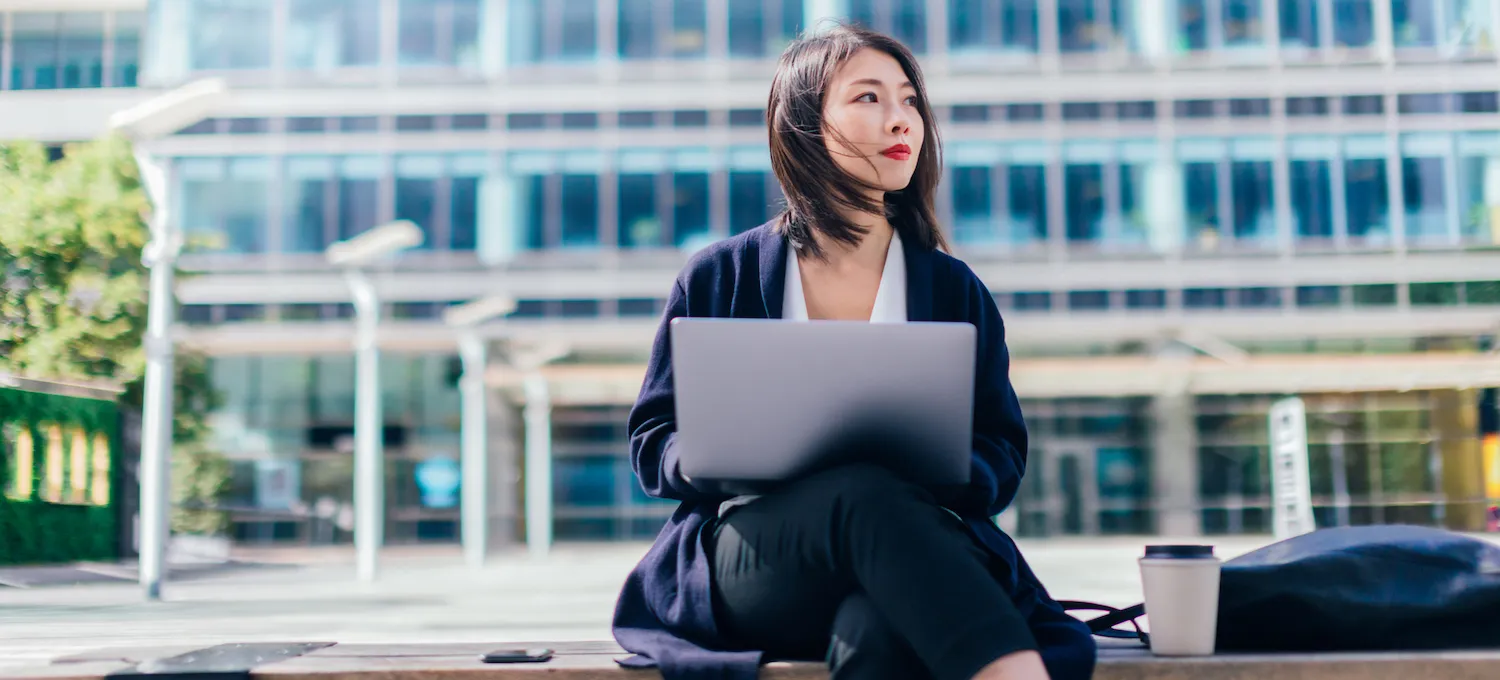 [Featured image] A young person sits outside with their laptop and gazes off in the distance, wondering, " Can you go to graduate school for a different major?"