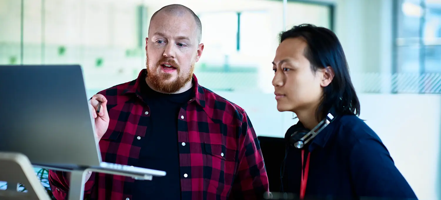 [Featured image] Machine learning professionals discussing the difference between SVM and decision trees in an office.