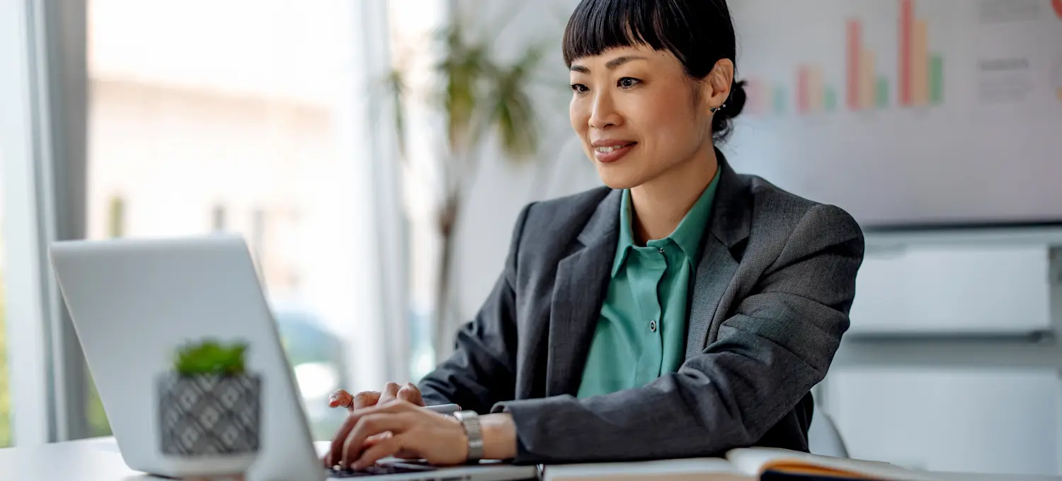 [Featured image] A data analyst wearing a business suit works with predictive analytics on their laptop in a sunny office setting.

