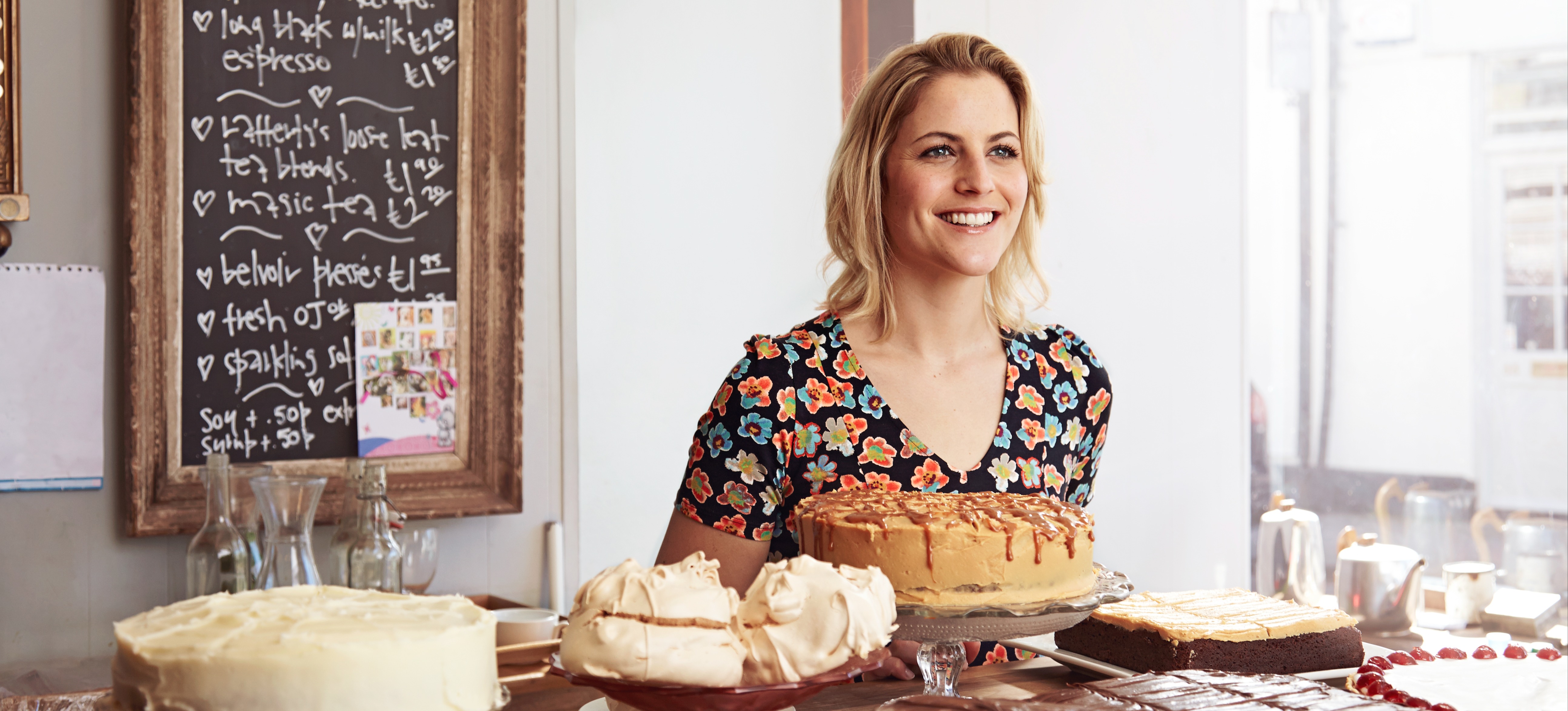 [Featured Image] An entrepreneur stands in her coffee shop that she opened after learning whether you need a business degree to start a business.   