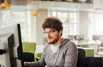 [Featured Image]:  DevSecOps engineer, wearing a gray sweatshirt, sitting at a desktop computer, analyzing information on the security of the software development process. 