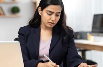 [Featured Image] A fraud analyst works on a case in her office.