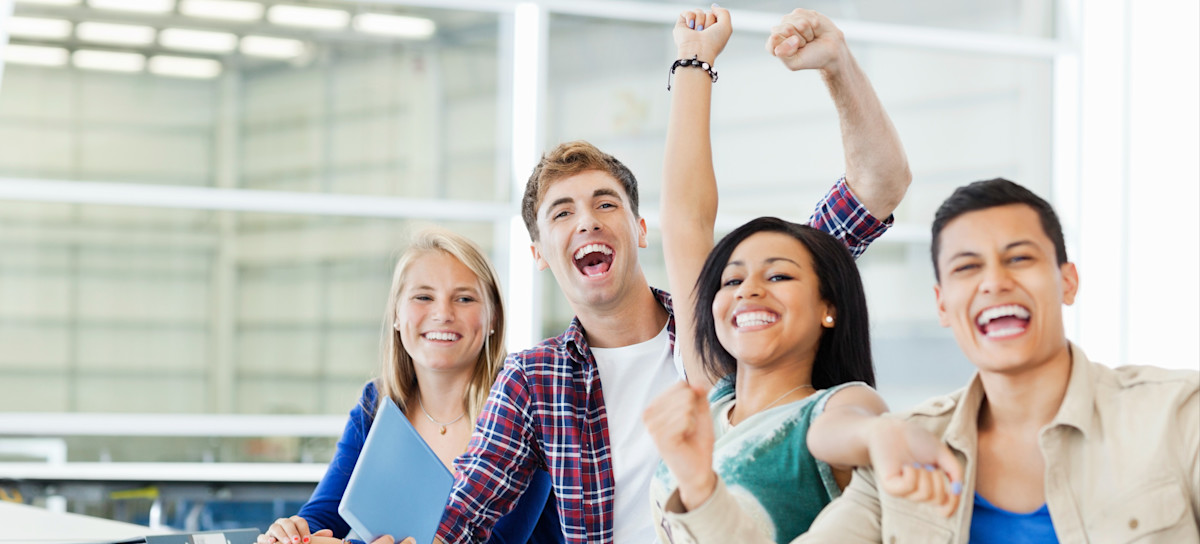 [Featured Image] Four college learners smile and cheer after learning about the bachelor’s degrees that require the least amount of math. 
