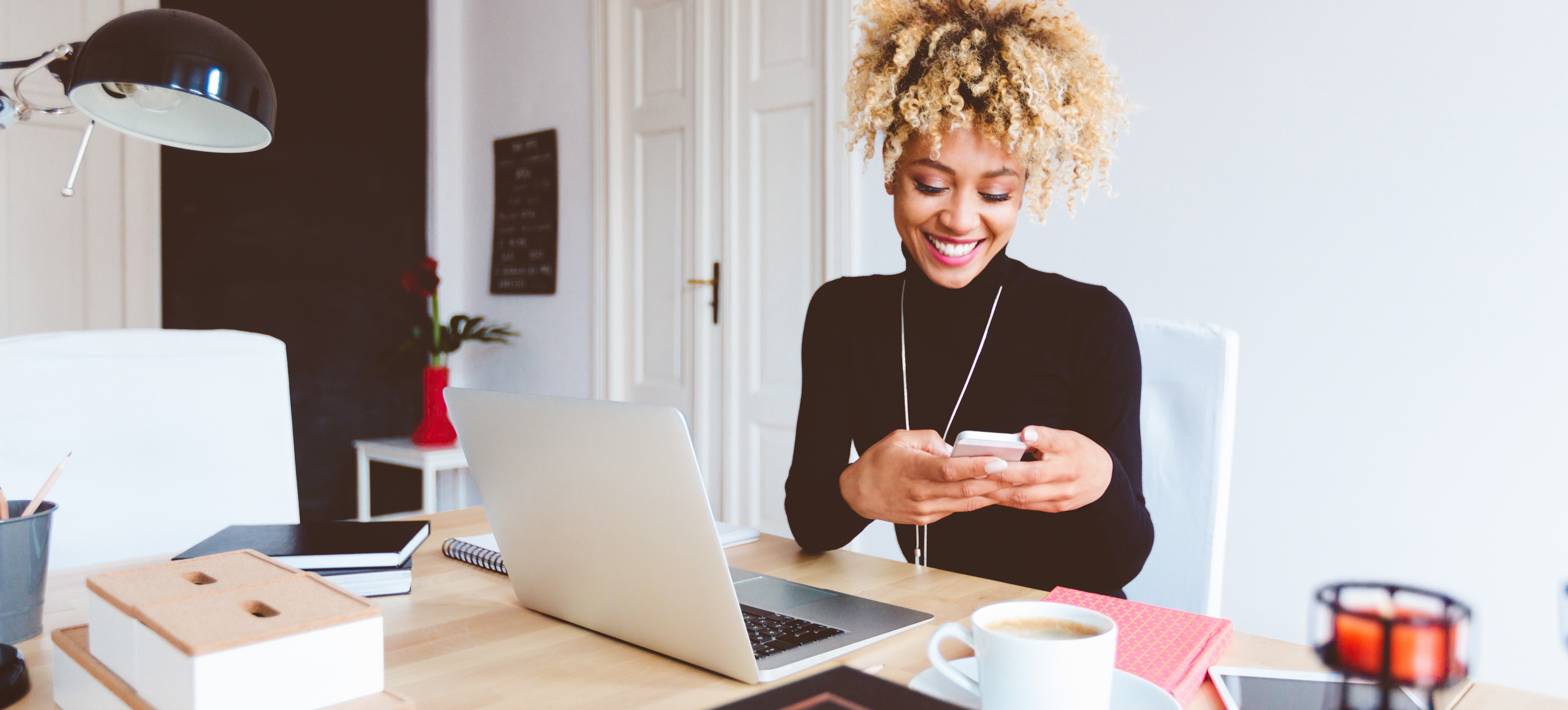 [Featured Image] A person looks at their phone and smiles as they assess the effectiveness of their Facebook advertising campaign.