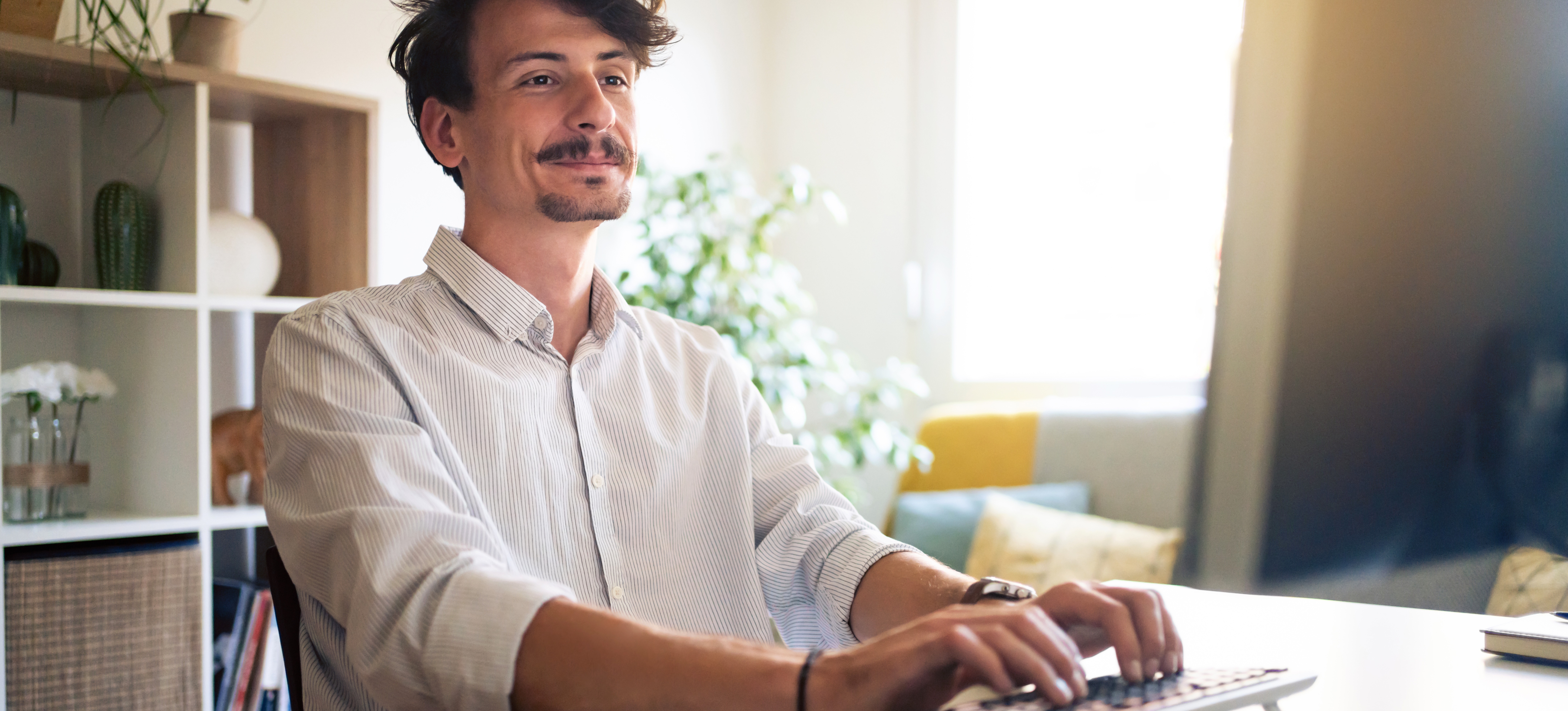 [Featured Image] A network engineer works on his computer to implement network monitoring software.   