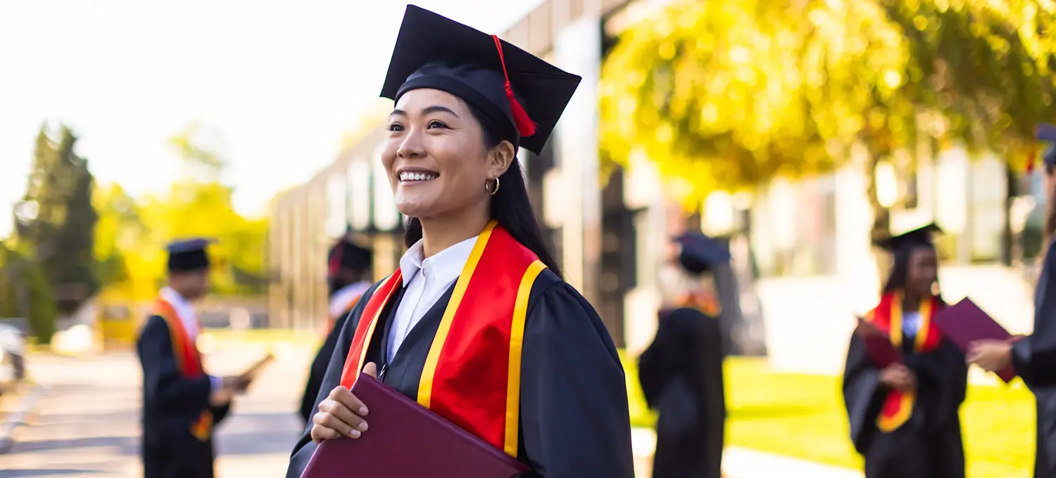 [Featured Image]: Graduate looking proud and holding their diploma.