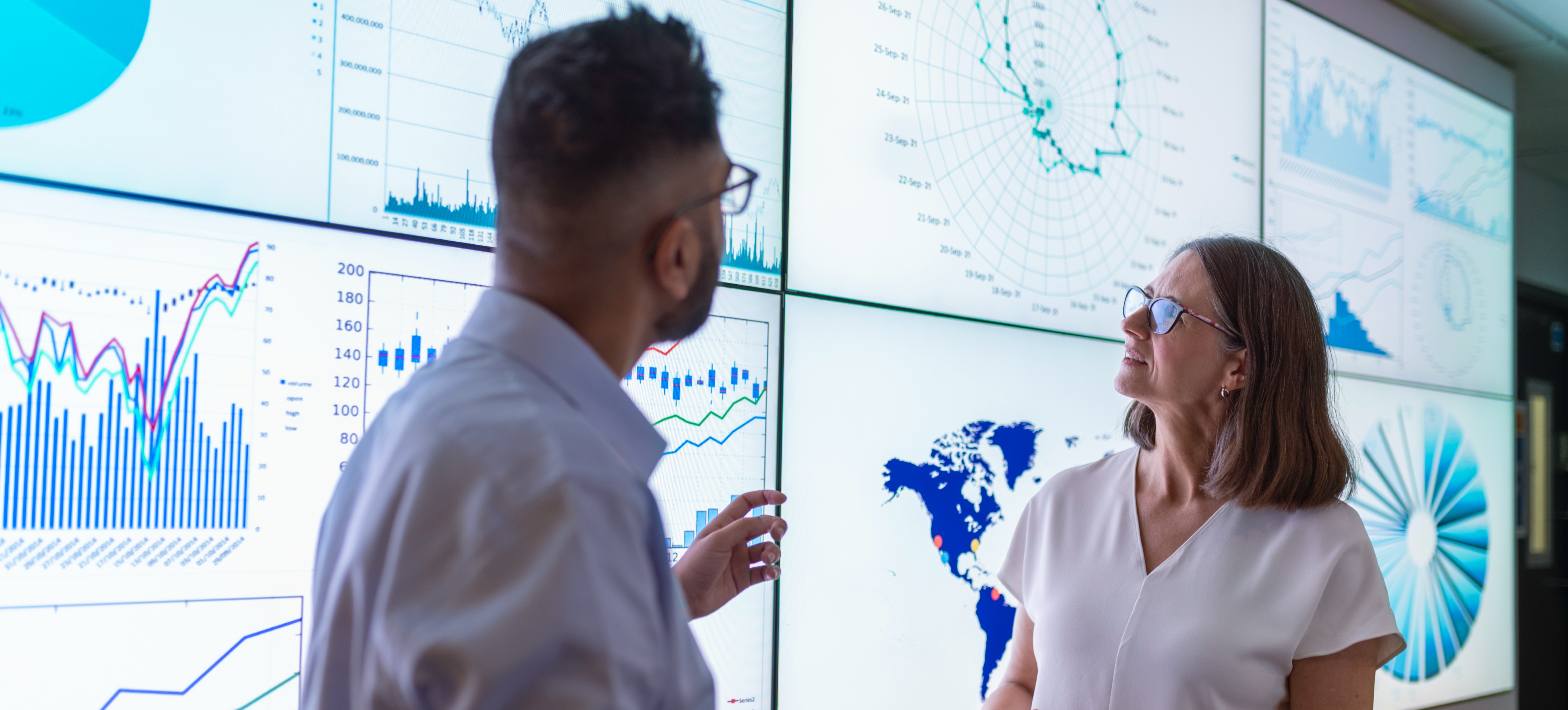 [Featured Image] Two professionals use data visualization examples to explain their newest operational strategies.
