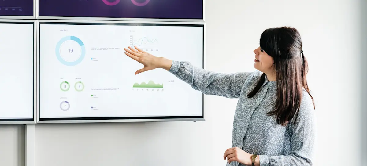 [Featured Image]: A health informatics specialist presents data on a large screen. 
