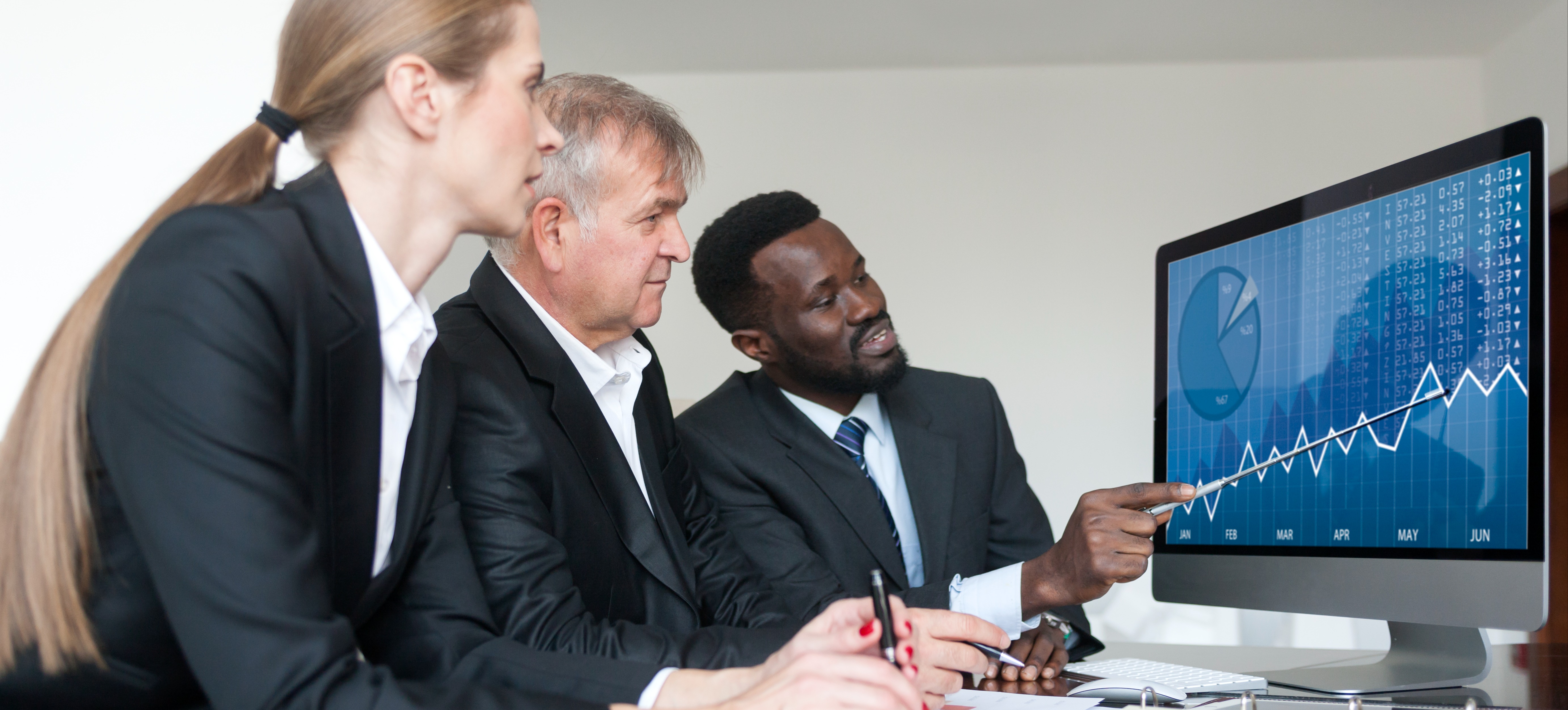 [Featured Image] Professionals in a workspace reviewing data charts while discussing certified data protection officer responsibilities.
