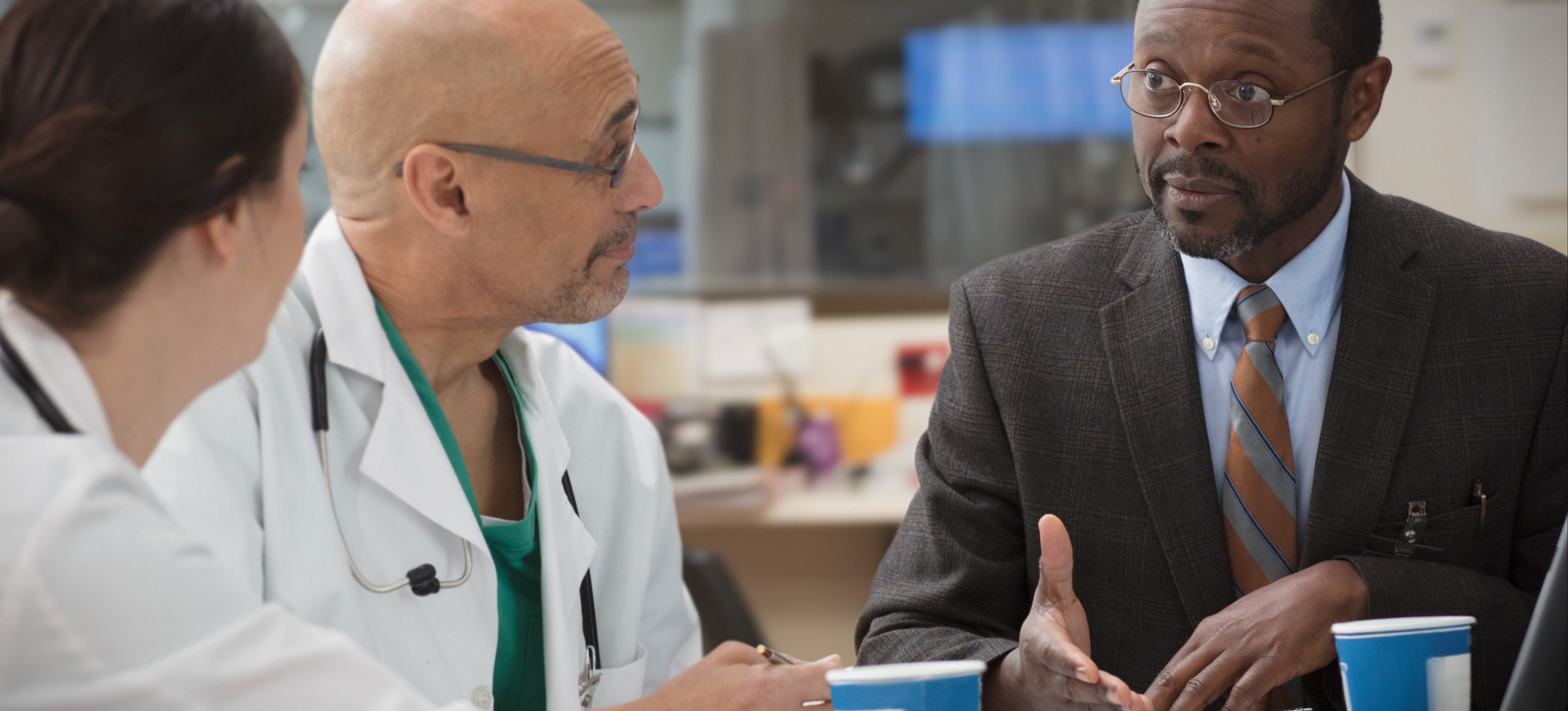  [Featured image] A doctor, clinical research associate, and business professional discussing research.
