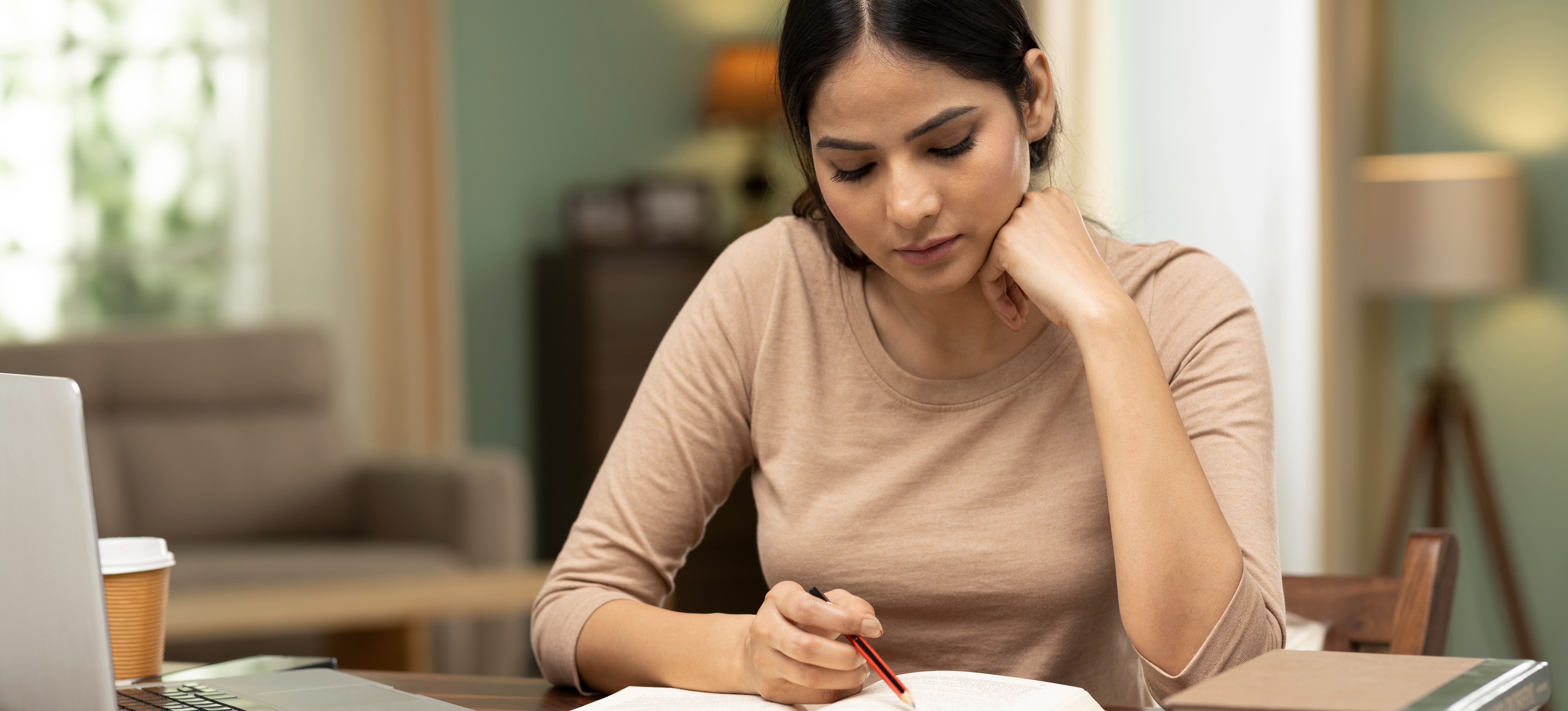 [Featured Image]: A student reads a book to learn what is a good SAT score as they prepare to apply to university programmes around the world.
