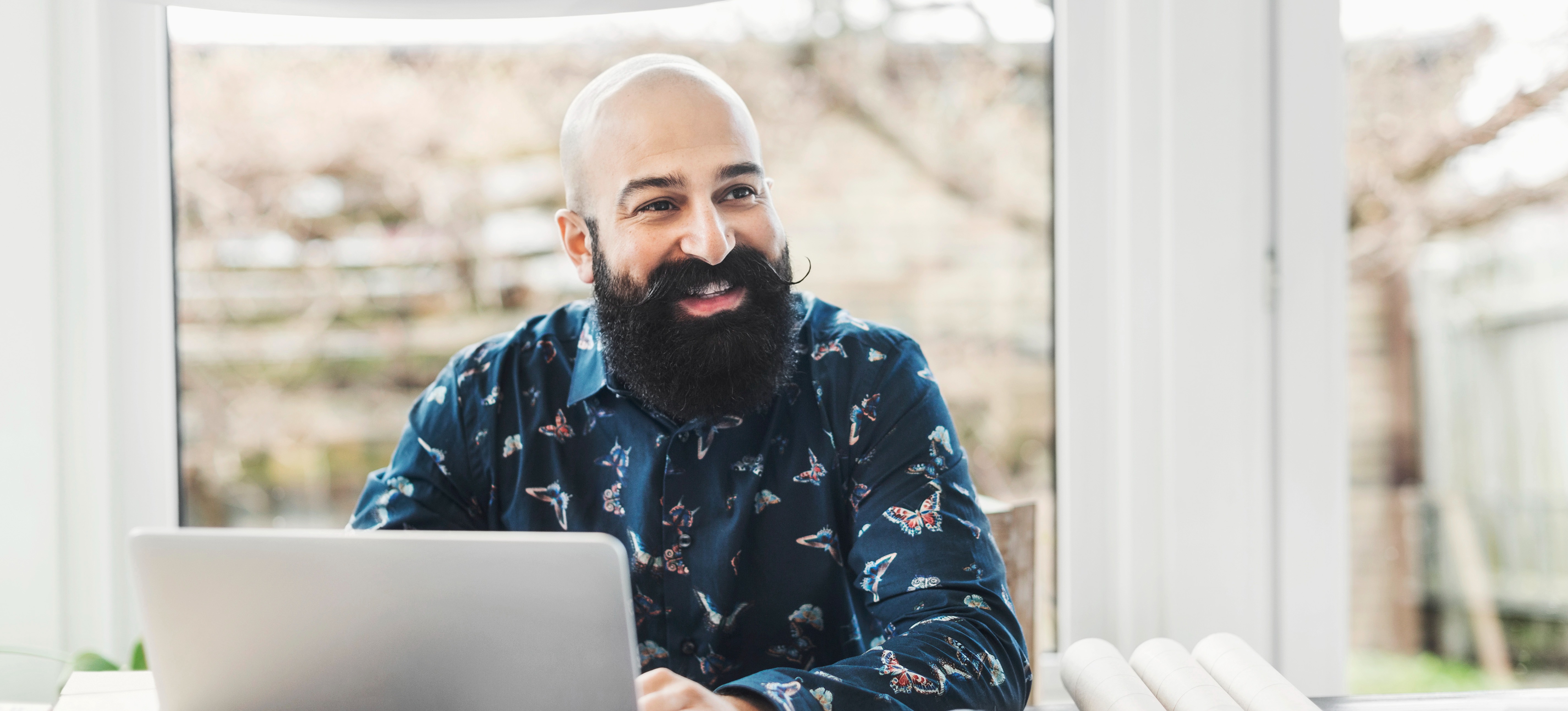 [Featured image] A SEO in a blue button-up shirt sits at a laptop checking the clickthrough rate (CTR) or their webpage.