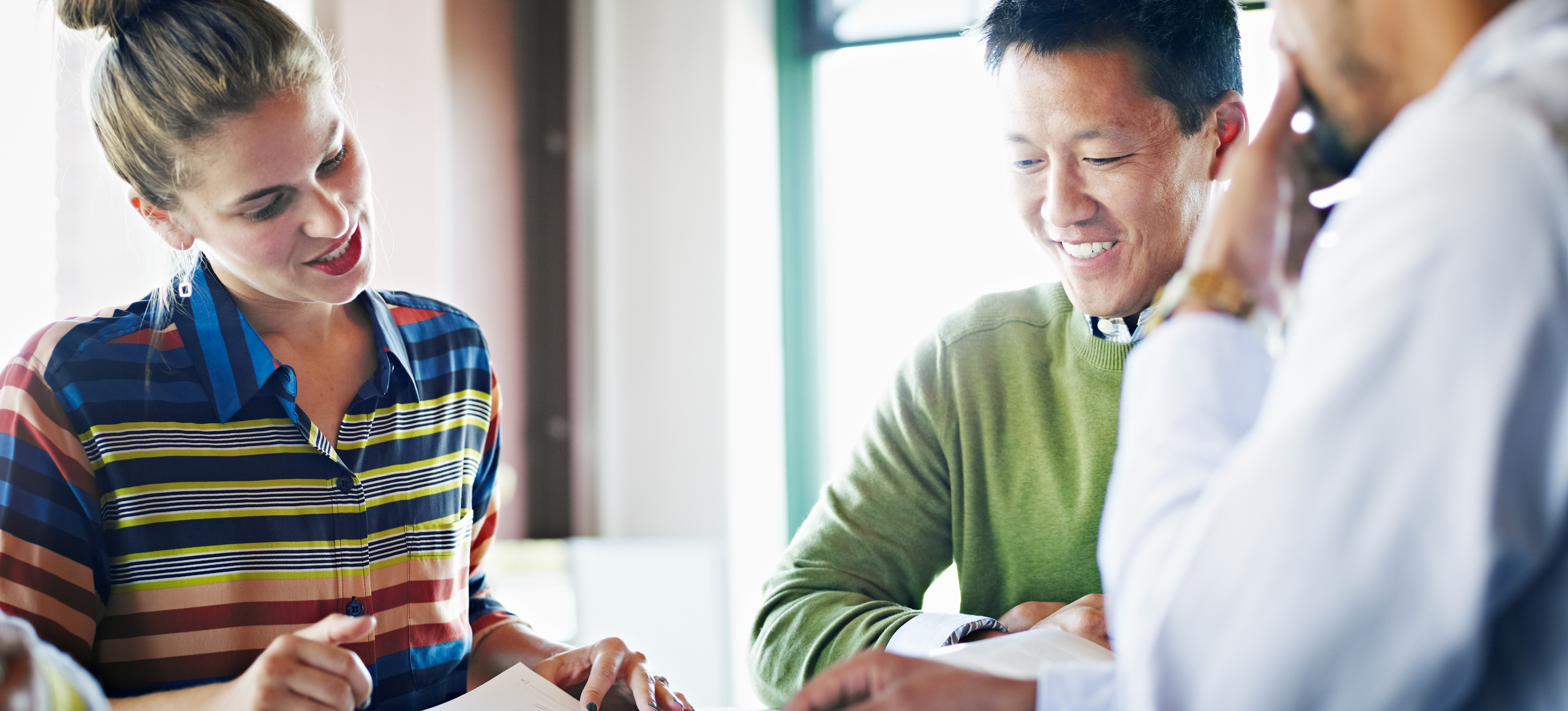 [Featured Image] A customer insight analyst meets with two company leaders to review their findings and begin strategizing how the business can better meet customers’ expectations. 
