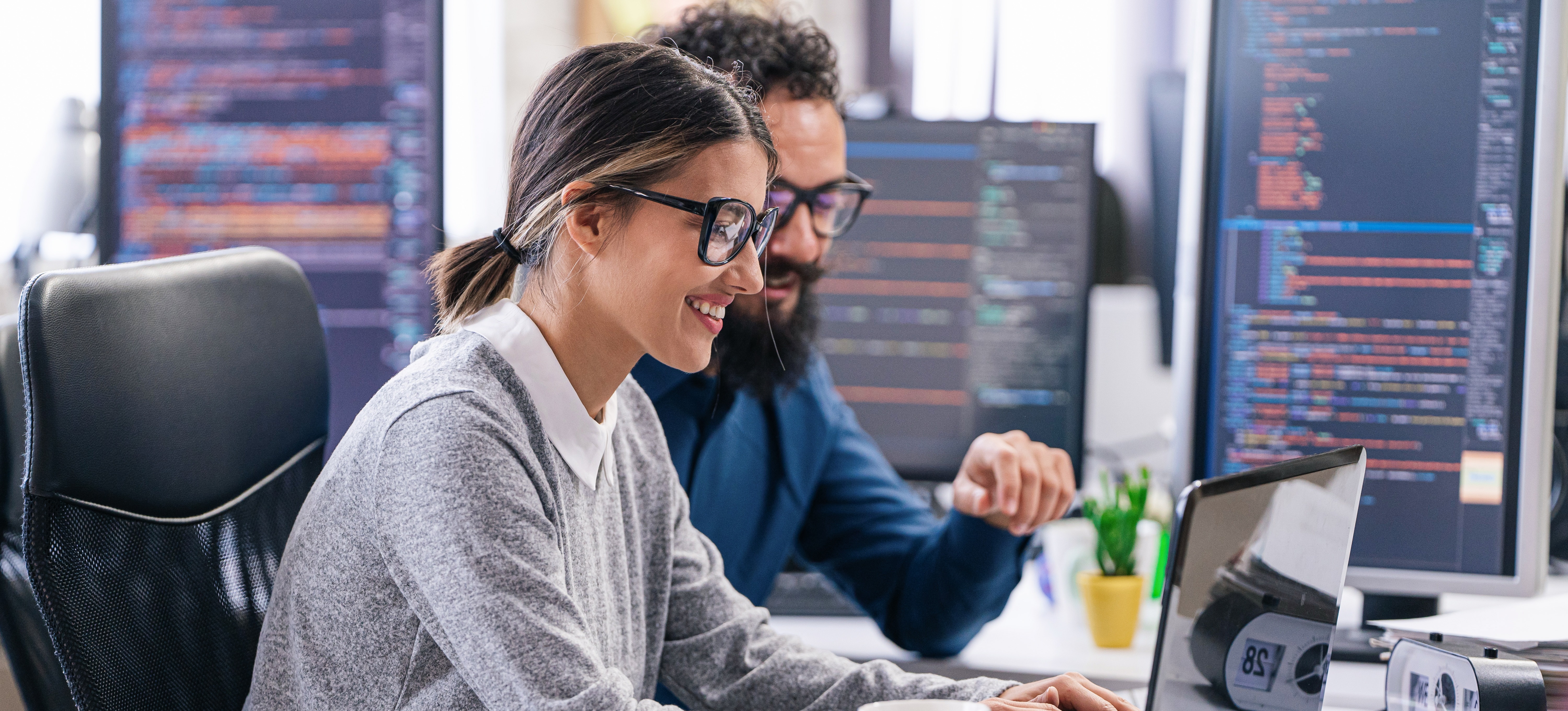 [Featured Image] Two AI professionals are collaborating in an office and discussing generative AI job responsibilities.
