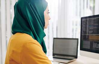 [Featured image] Woman at computer reviewing data