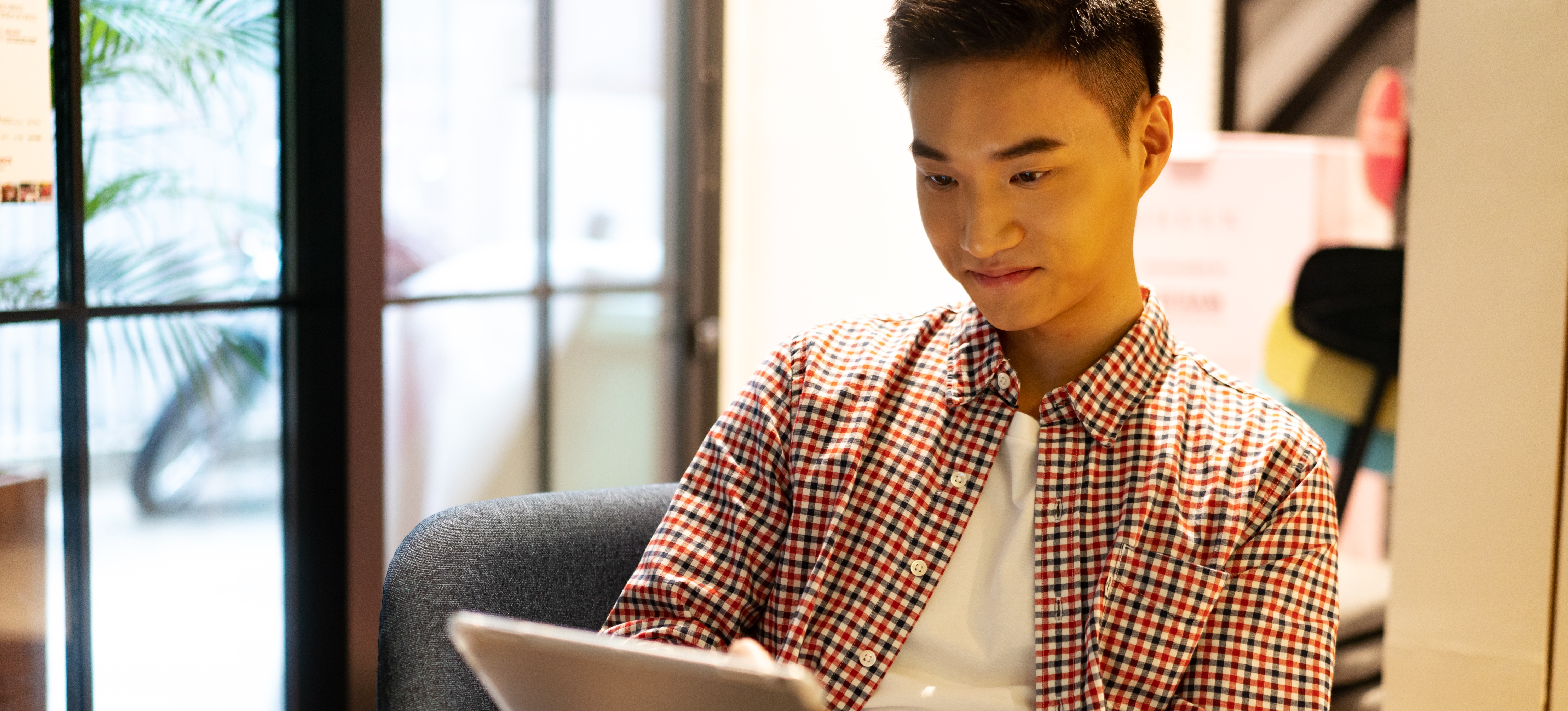 [Featured Image]: A person uses a tablet to apply their knowledge of image processing to digital photos needed for a project.
