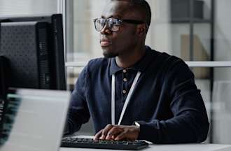 [Featured image] A white hat hacker works on a computer in an office.