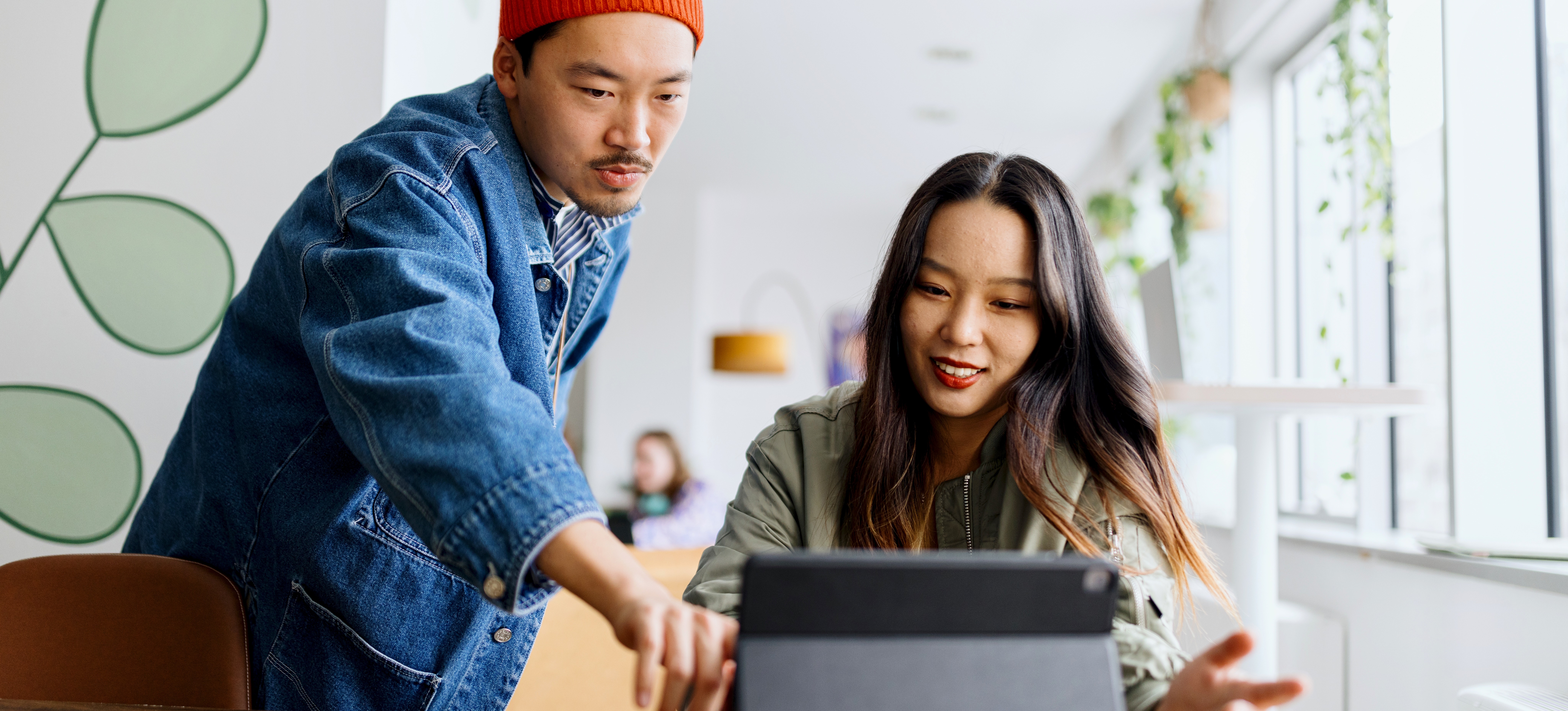 [Featured Image] Two employees discuss their company’s social media content strategy.
