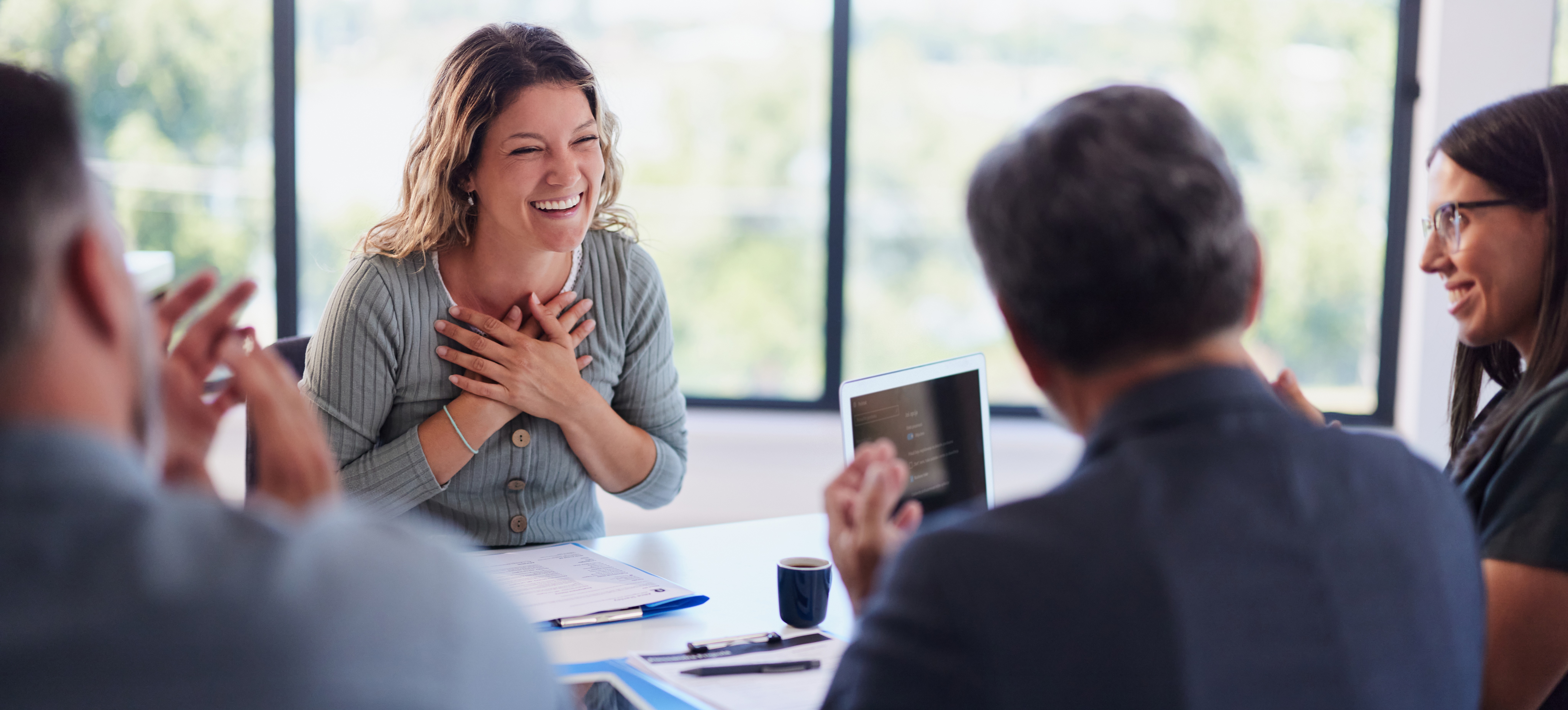 [Featured Image] A group of recruiters interviewing a candidate in a professional setting, reviewing a resume during the discussion about the prompt engineer role.
