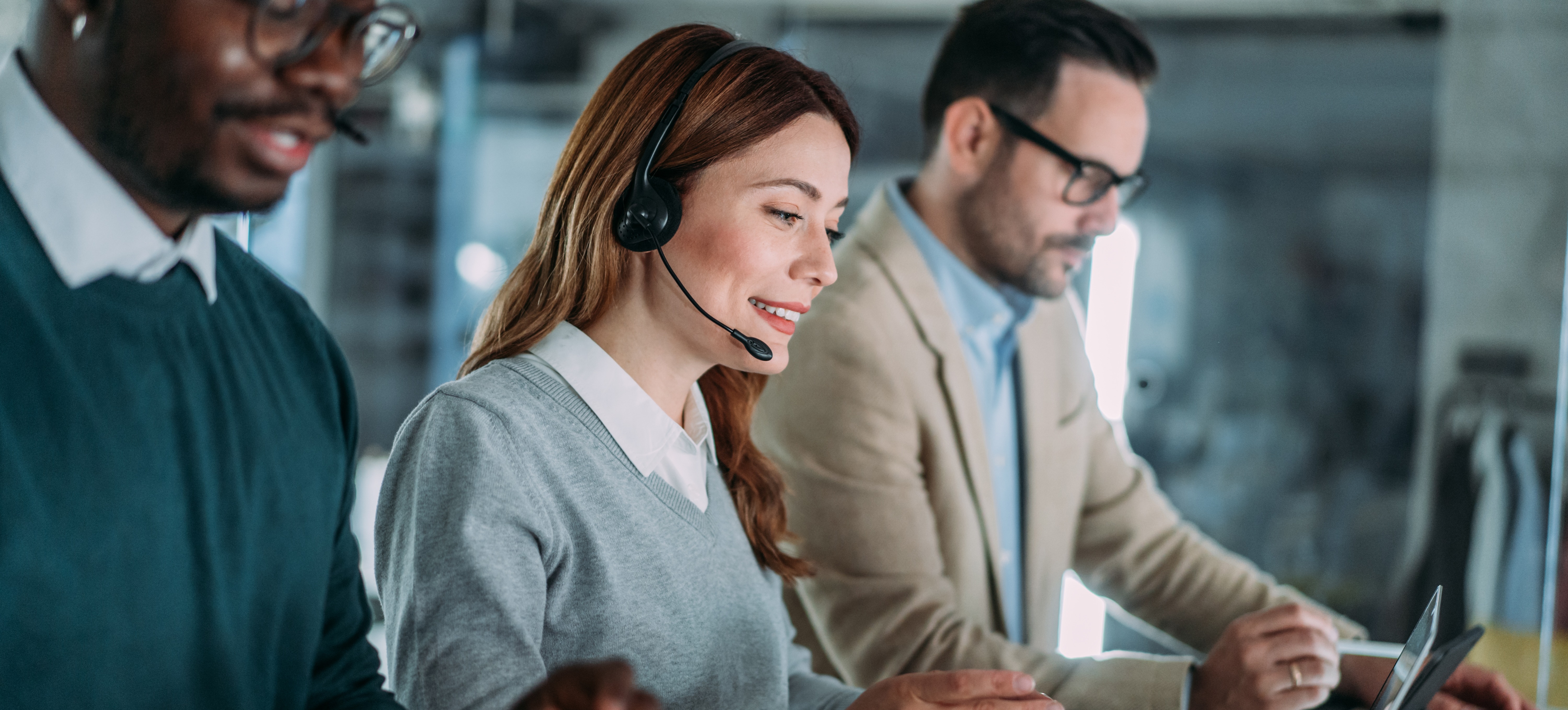[Featured Image] Professionals in a work environment interacting with their computers and learning about ERP vs. CRM.
