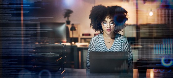 [Featured Image] A blockchain developer uses a laptop while working in her office.