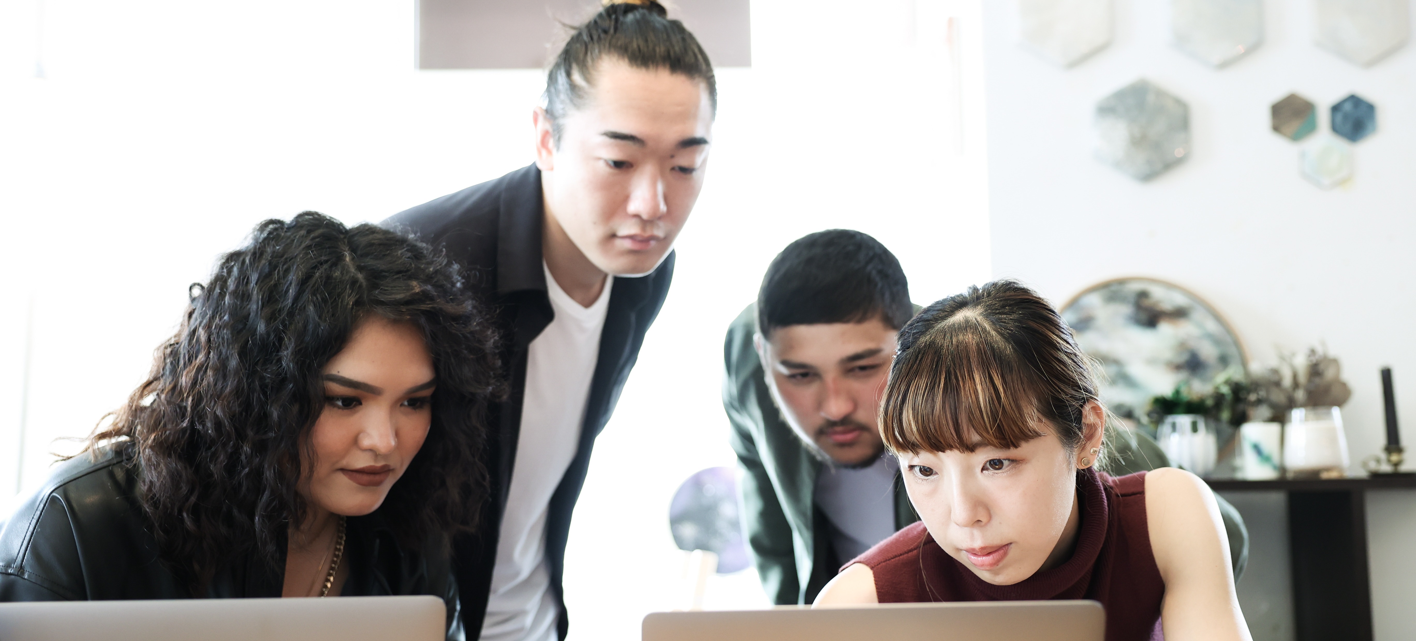 [Feature Image] Learners study together on laptops in a brightly lit room as they cultivate digital transformation leadership skills to advance their careers.
