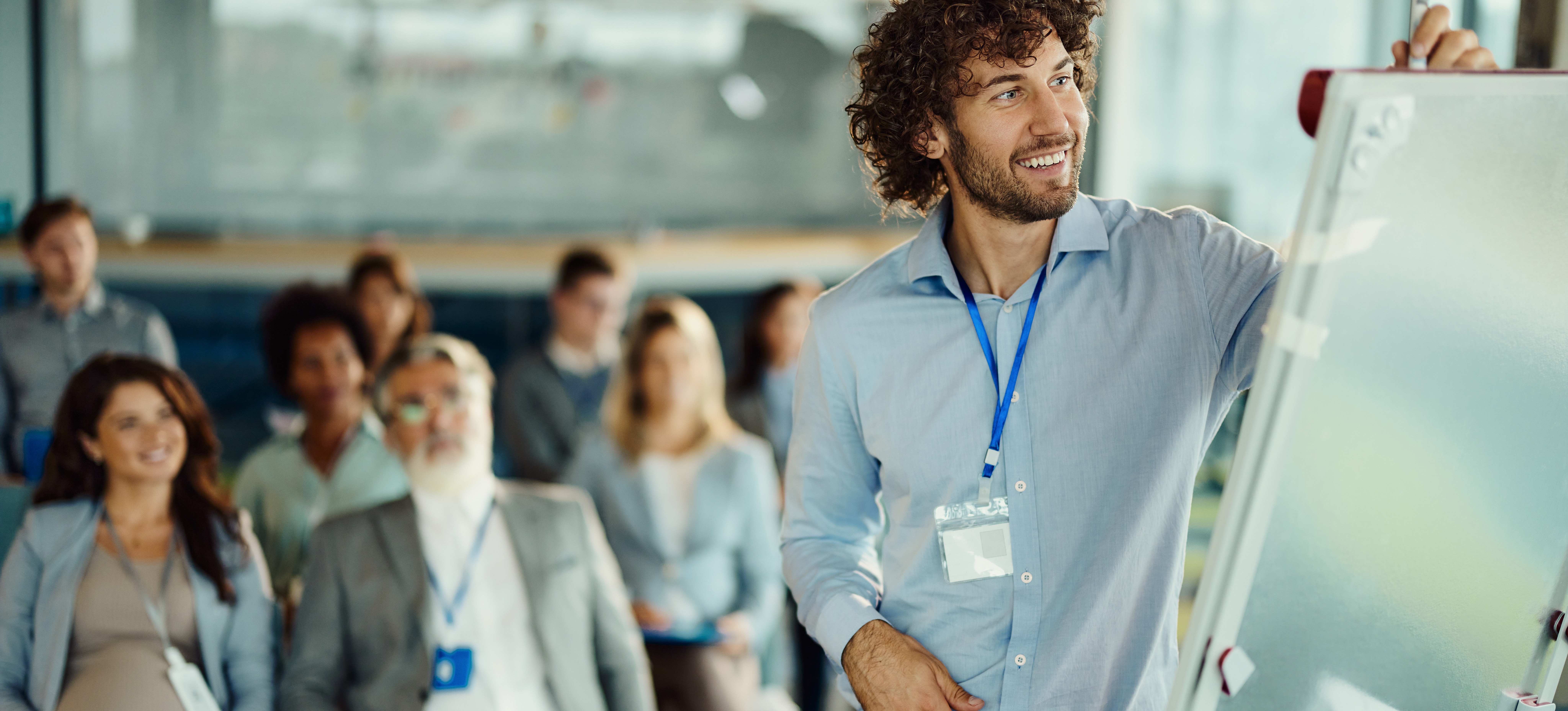 [Image en vedette] Un responsable anime une session de formation avec un groupe d'employés après avoir appris comment évaluer les besoins en formation.