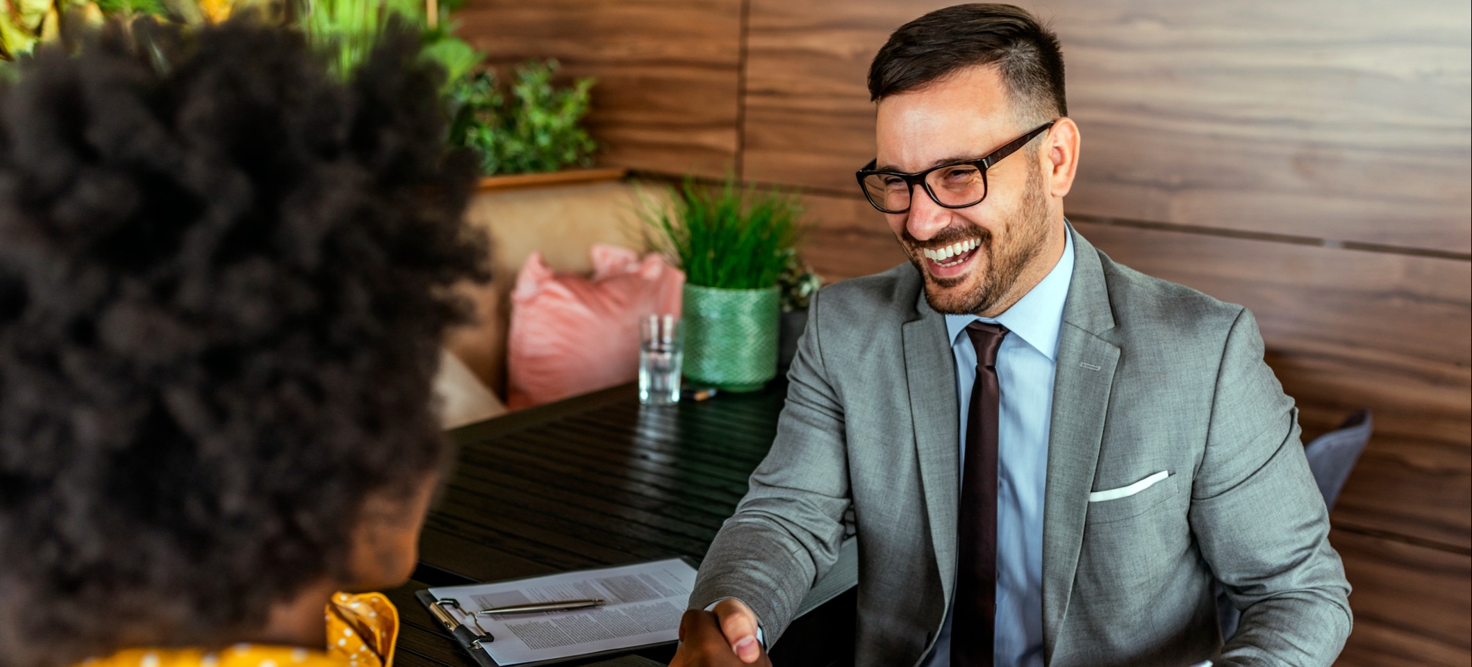 [Featured Image] Occupational therapist in a suit and tie meets with a client.