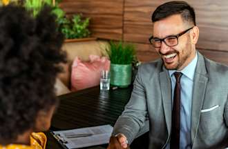 [Featured Image] Occupational therapist in a suit and tie meets with a client.