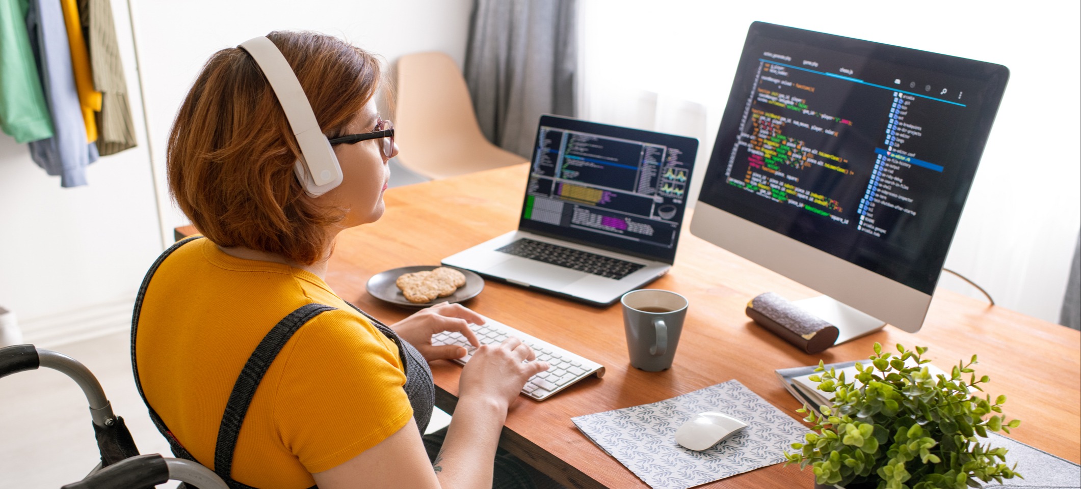[Featured Image] A blockchain developer in a wheelchair works on code in front of several monitors.

