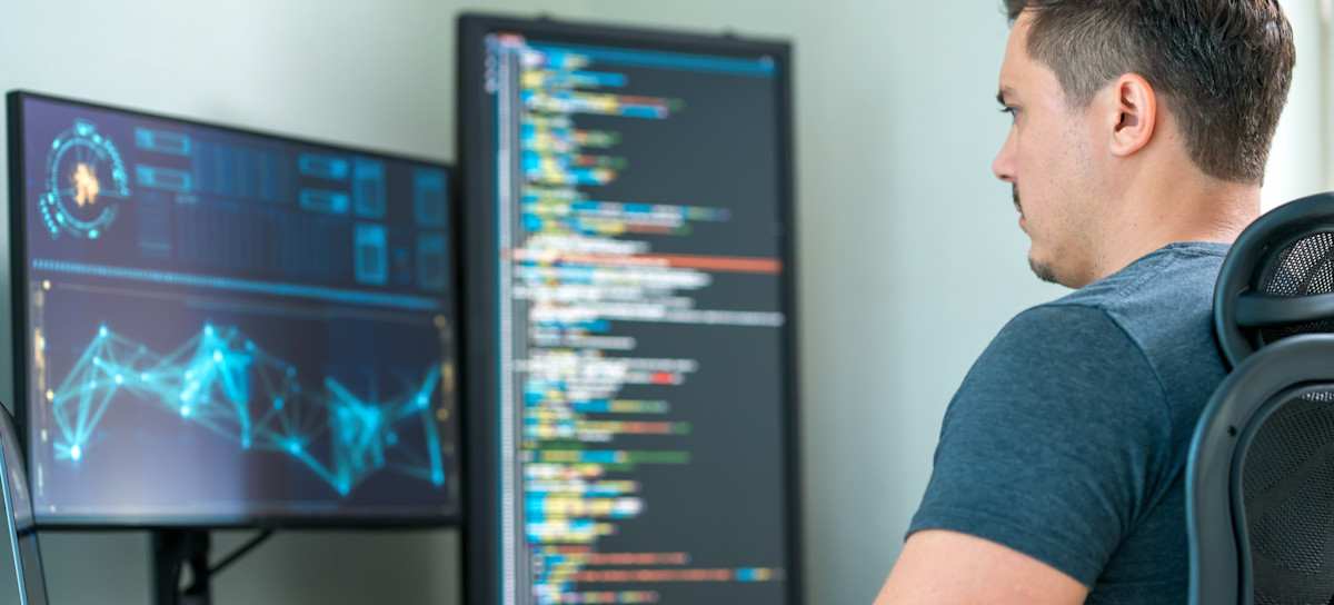 [Featured Image] A computer programmer writes code to guide AI integration into existing systems.
