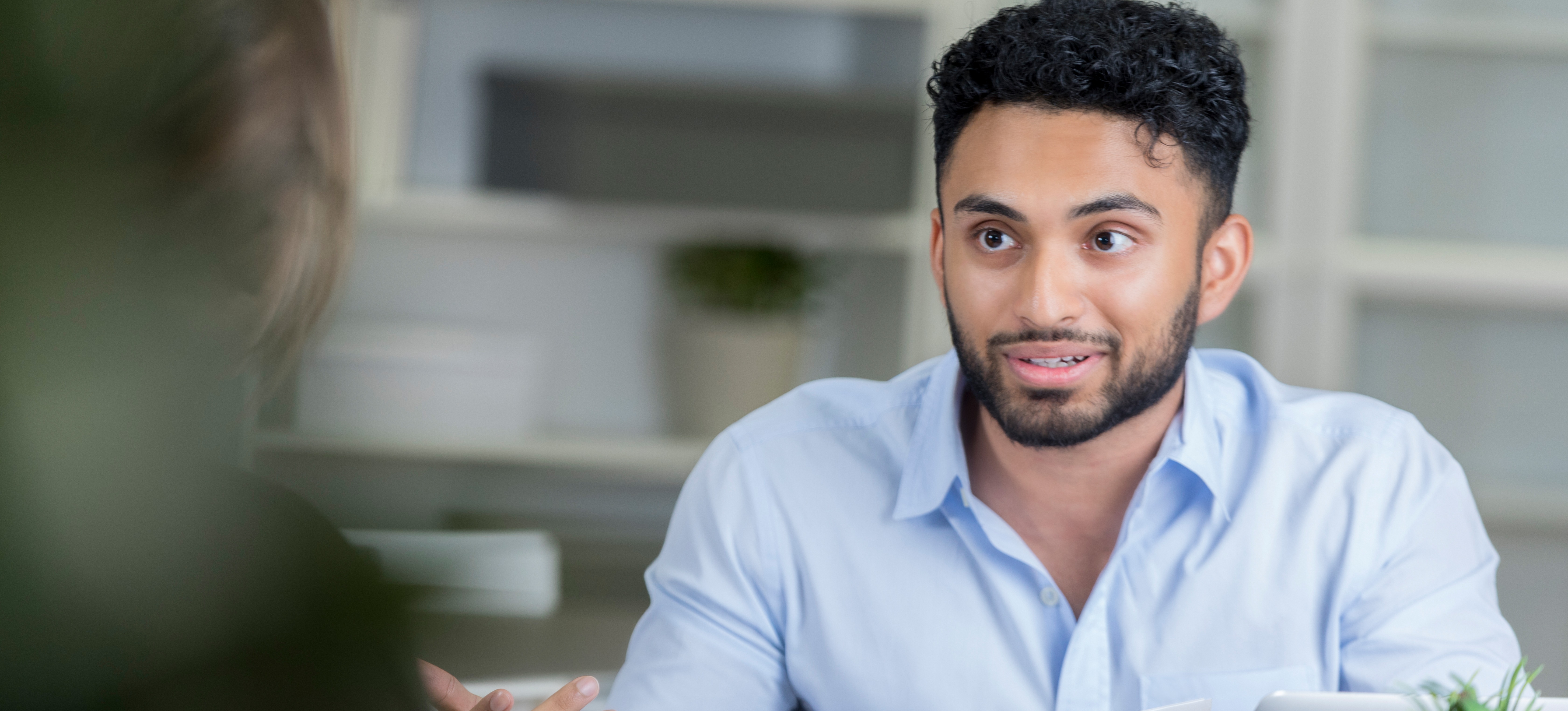 [Featured Image] A young job applicant discusses how to write a CV with no experience with a career counselor. 
