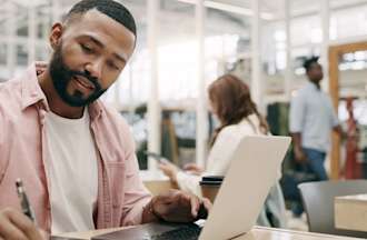 [Featured image] A data analyst sits at a laptop and takes notes on some data he discovered with high data granularity.  