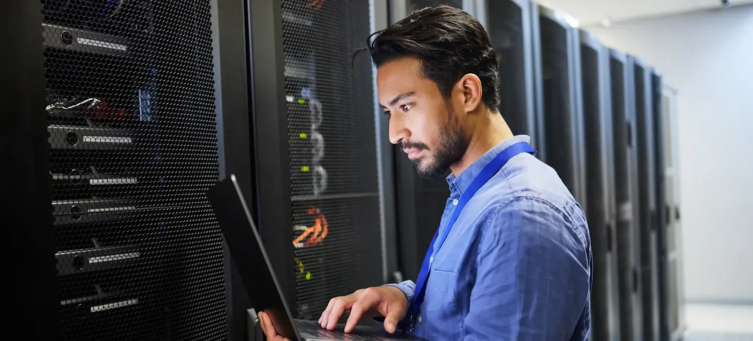 [Featured Image]: A network engineer works in a server room, illustrating how Dijkstra's algorithm supports network routing and shortest-path calculations.
