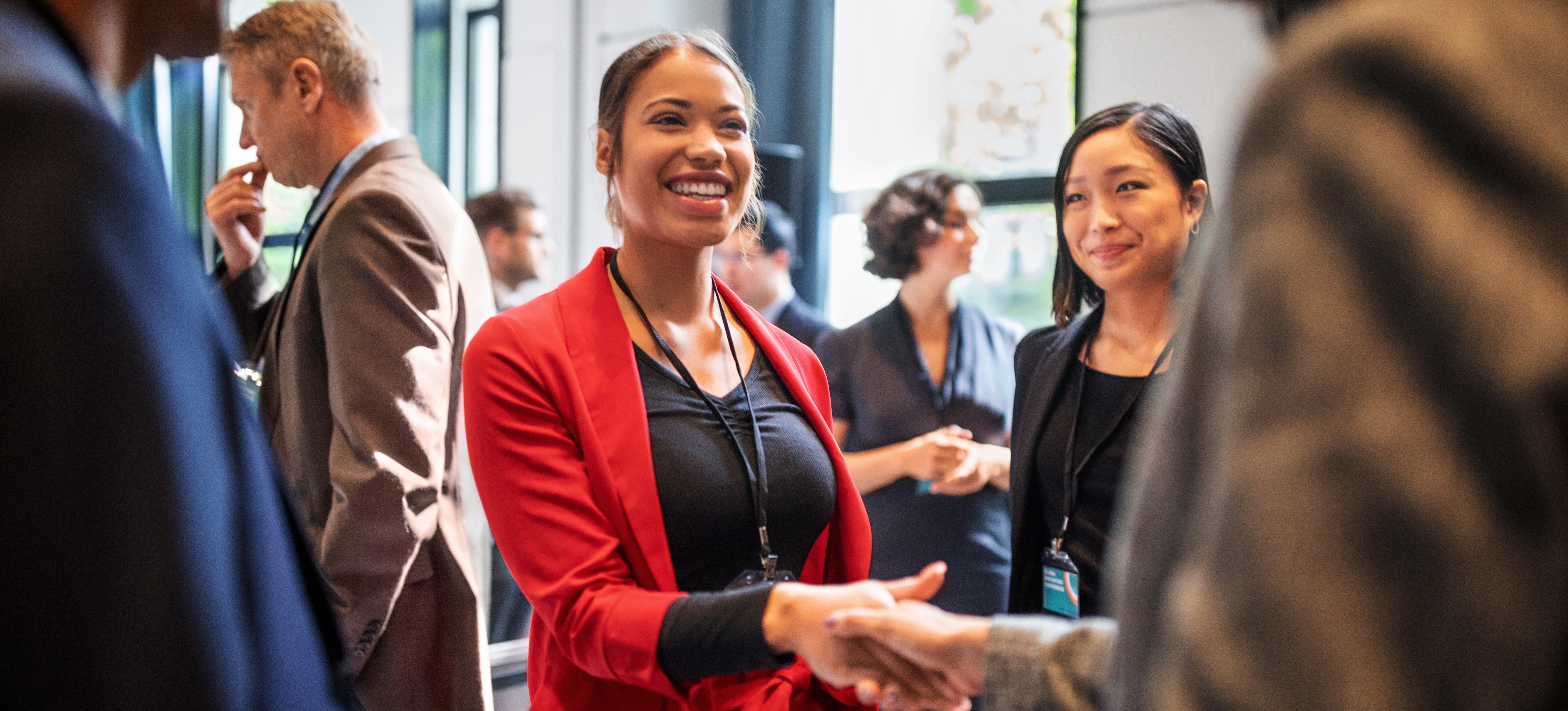[Image en vedette] Un leader charismatique accueille un collègue lors d'une conférence.
