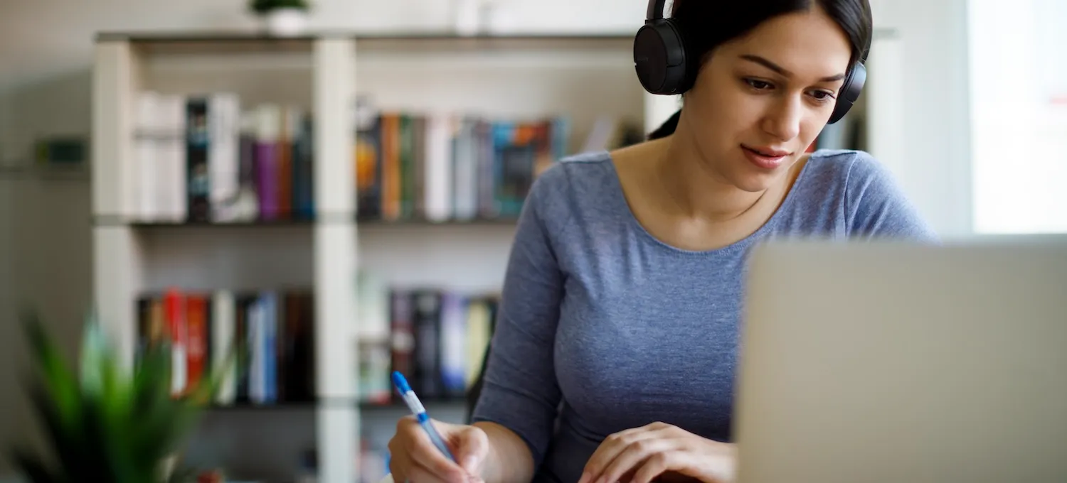 [Featured image] A young person wearing headphones looks at their laptop and takes notes about transcript evaluation.