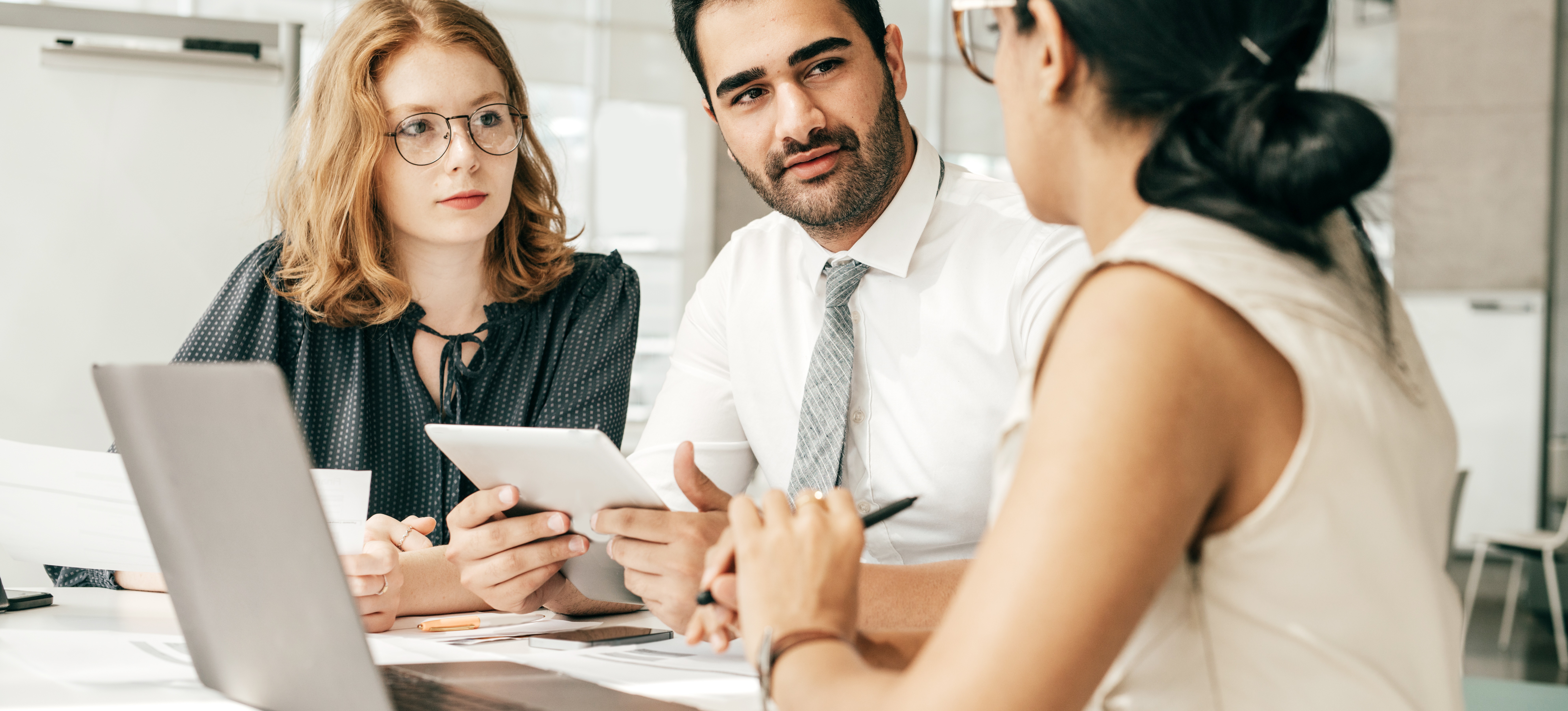 [Featured Image] Three data scientists sit in an office and discuss whether they will use Keras for various AI tasks. 