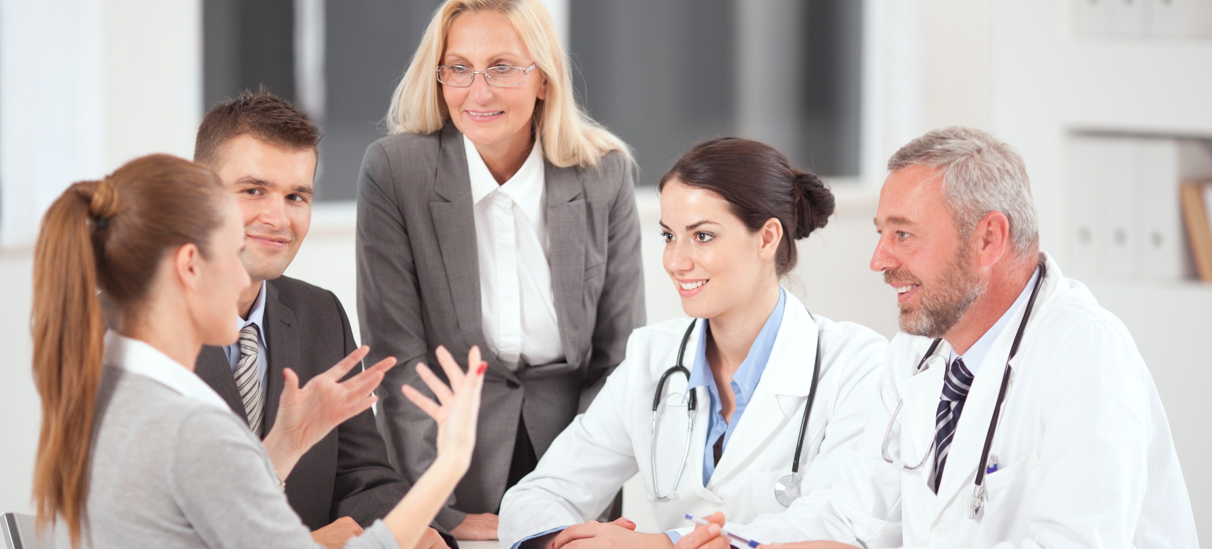 [Featured image] A group of medical professionals interviews a candidate for a healthcare cybersecurity role opening. 
