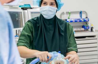 [Featured Image] A nurse anesthetist cares for a patient. 